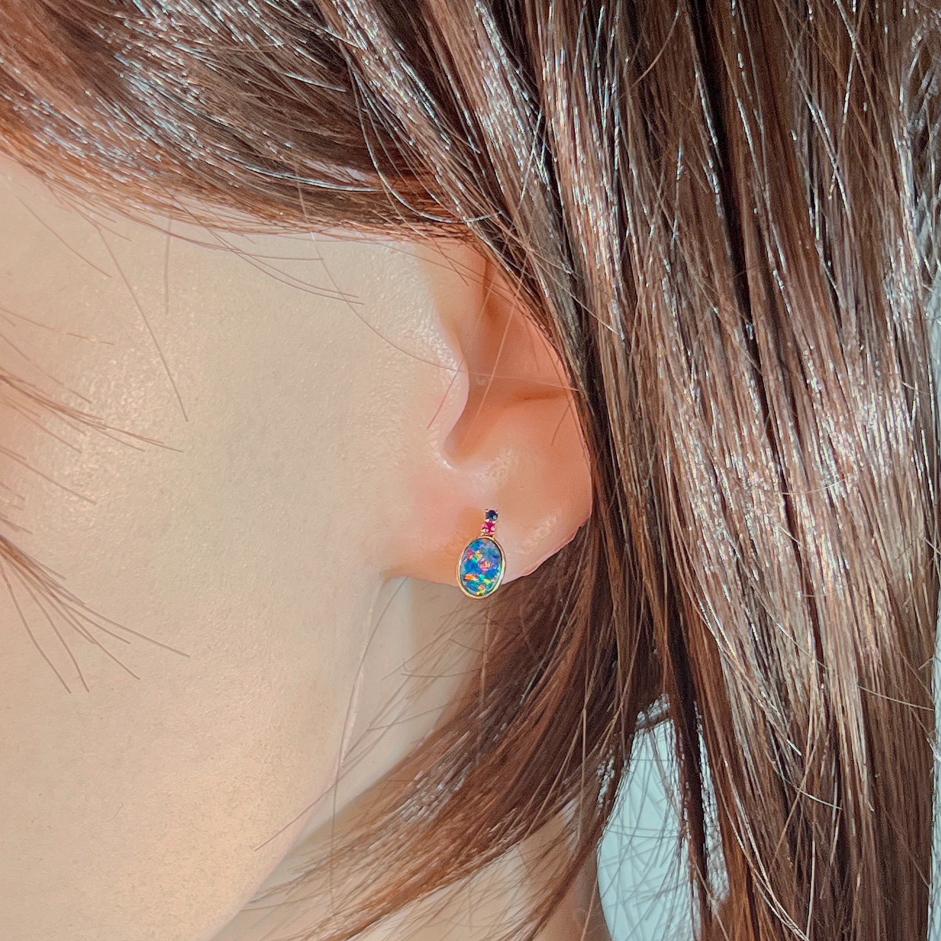 14kt rose gold opal doublet stud earring worn on the ear beneath loose hair