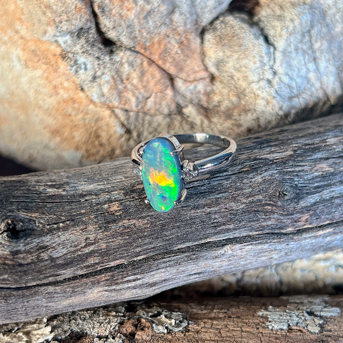 Oval black opal ring, 13.1 x 6.7mm Australian black opal set in 18kt white gold with two diamonds