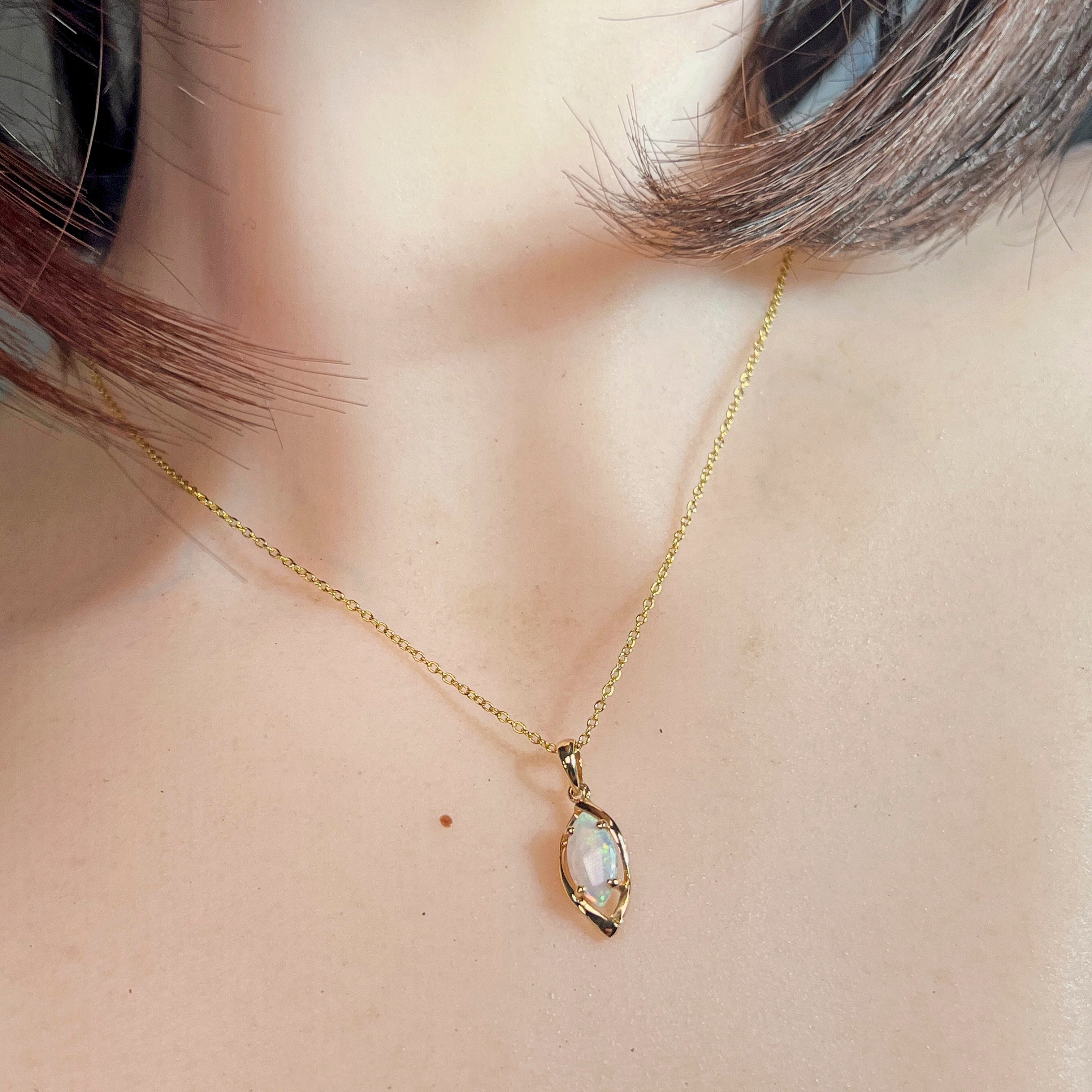 Worn view of the 0.5ct marquise crystal opal pendant in 9kt yellow gold
