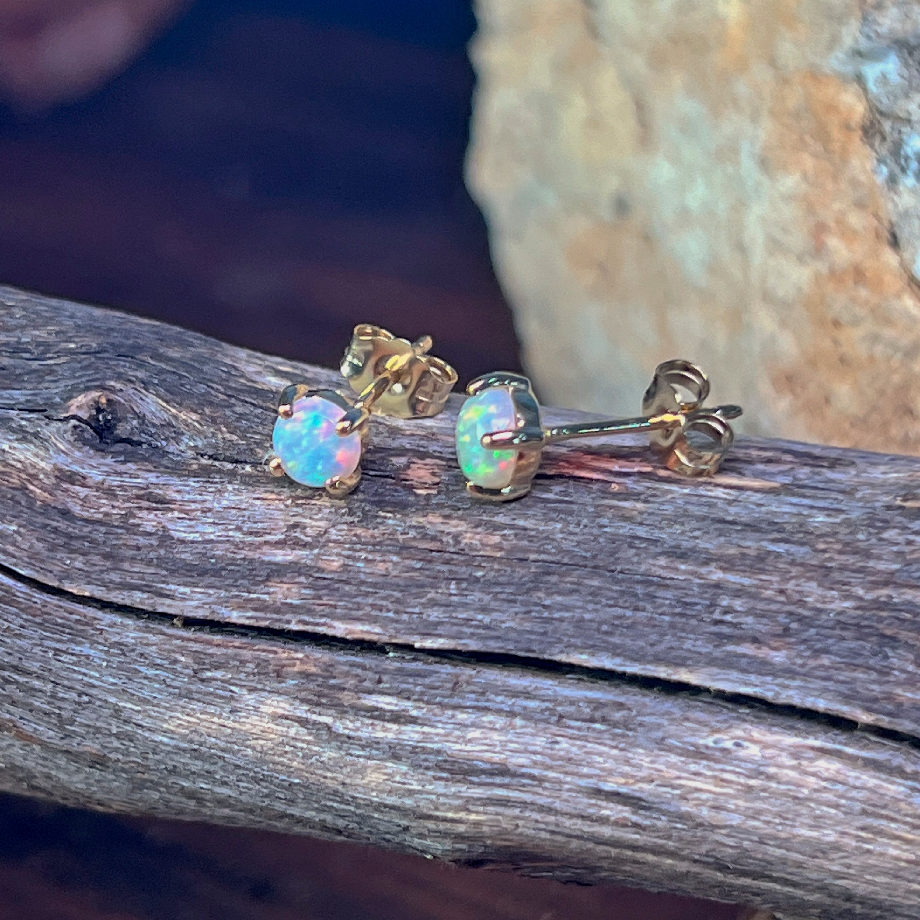 Crystal opal studs in yellow gold showing green and pink play-of-colour