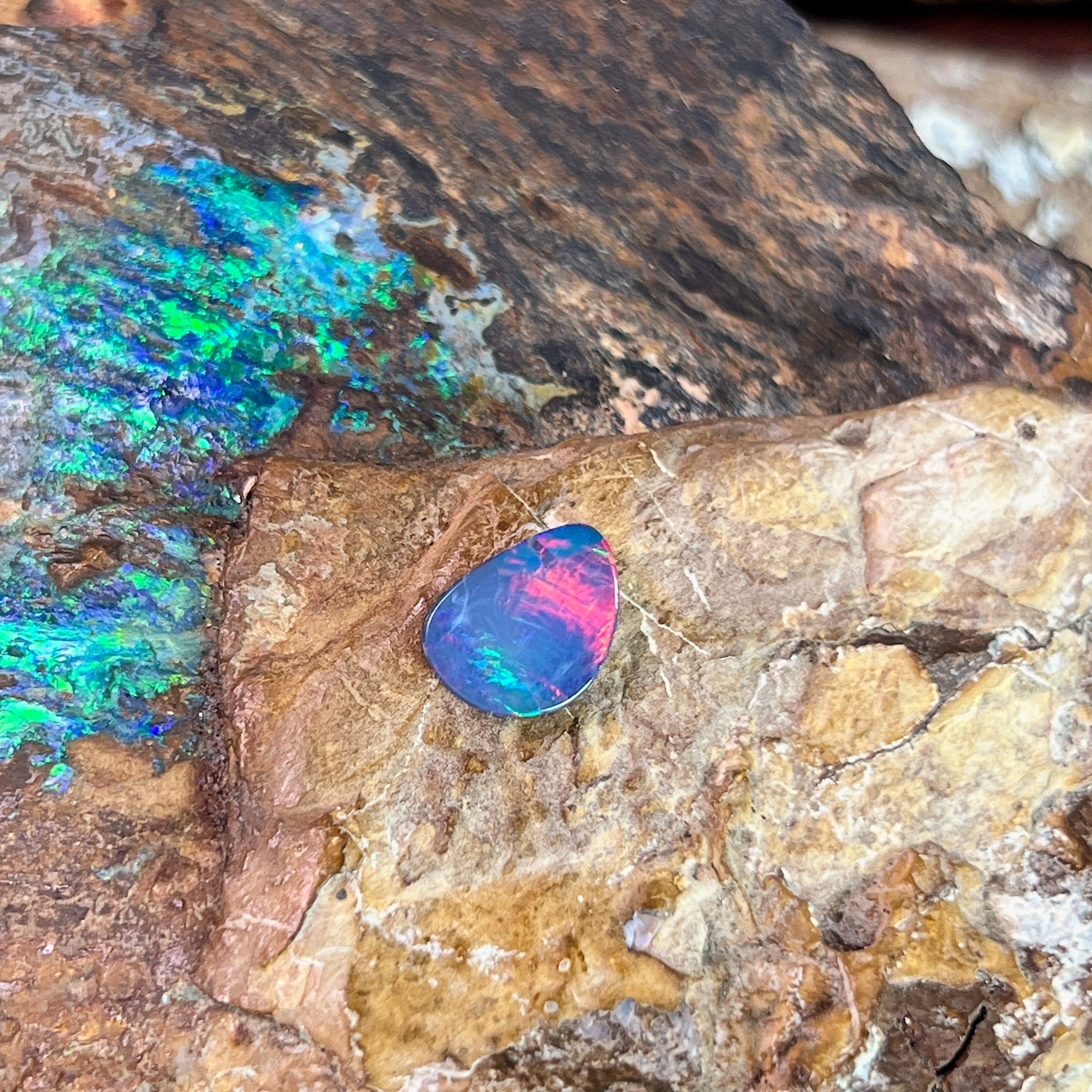 1.47ct Australian opal doublet on ironstone, rose-red flash rolling across a violet body