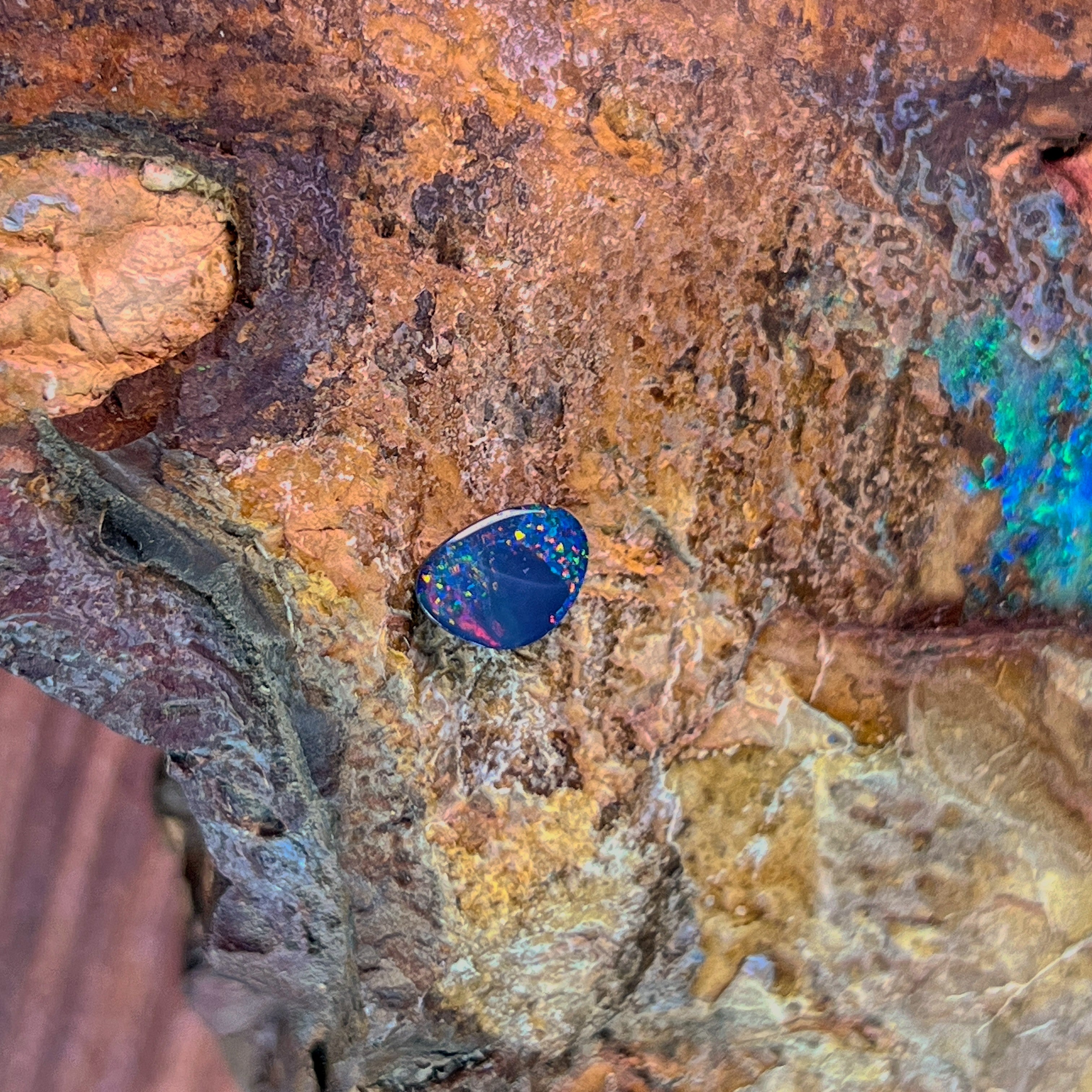 0.78ct Australian opal doublet on ironstone, pinfire specks of red and gold over violet