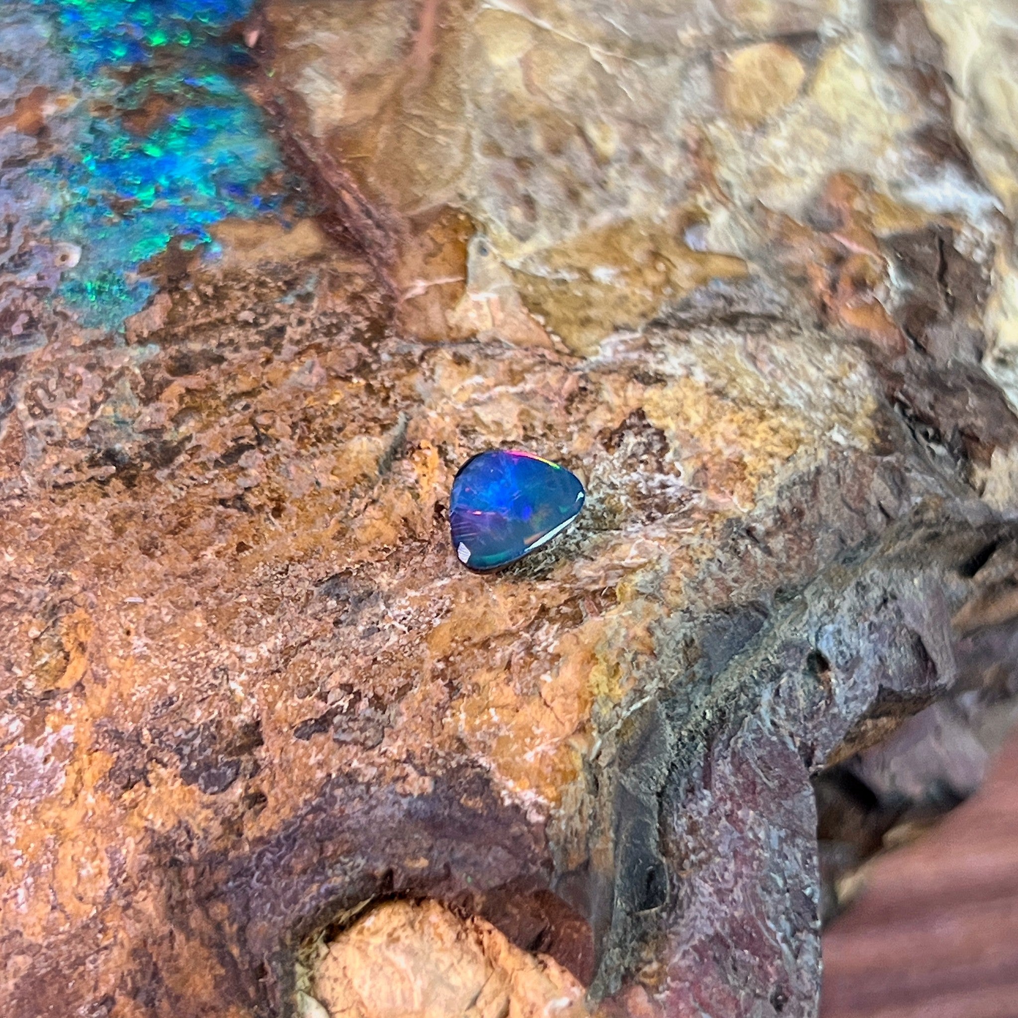 Magenta and blue play-of-colour in a freeform 0.70ct Australian opal doublet on ironstone