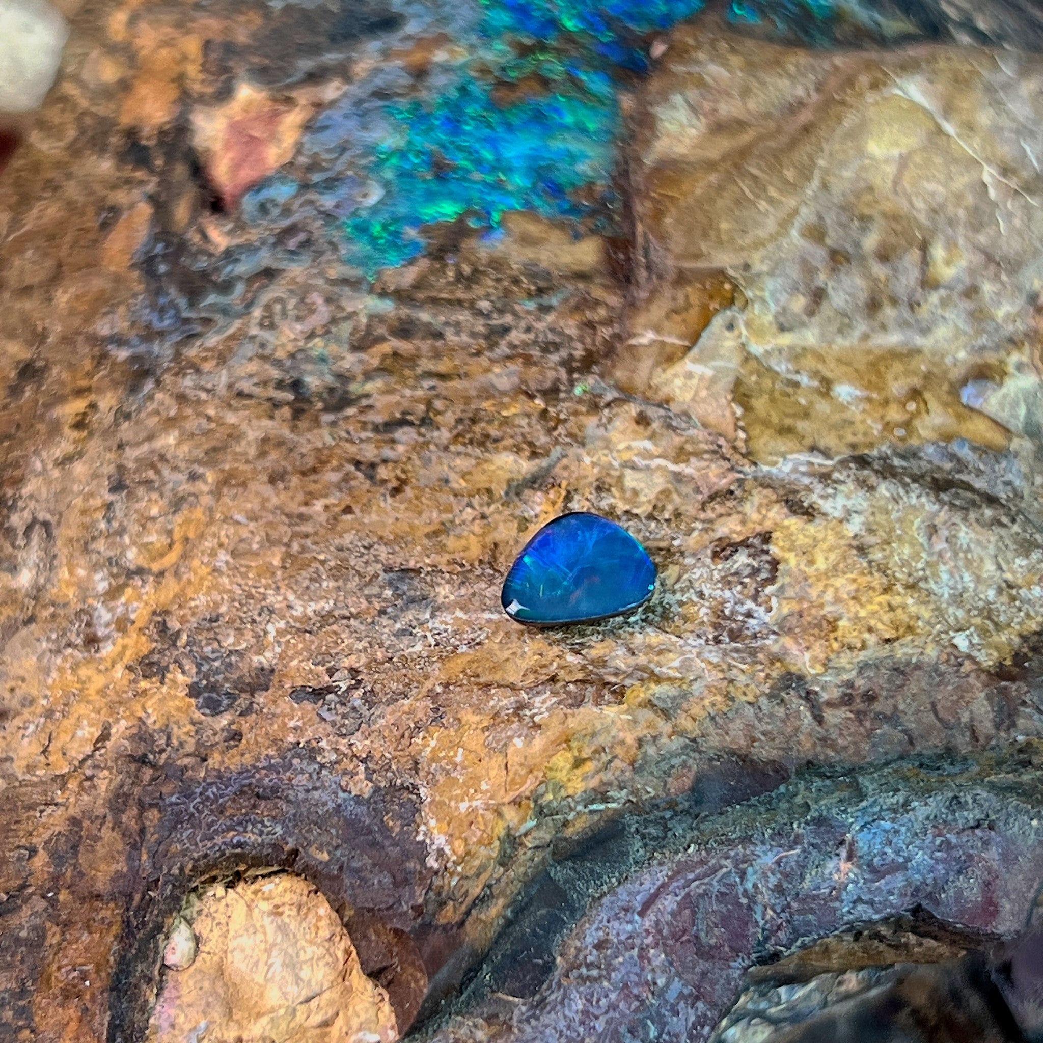 Deep blue violet in a 0.70ct freeform Australian opal doublet against pale ironstone