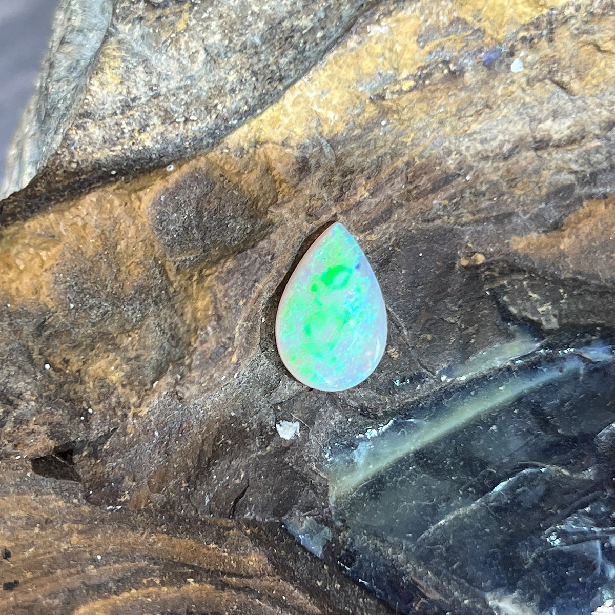 Loose solid crystal opal 1.15ct, pear shape, green and yellow play-of-colour, ready for a custom setting, on rock