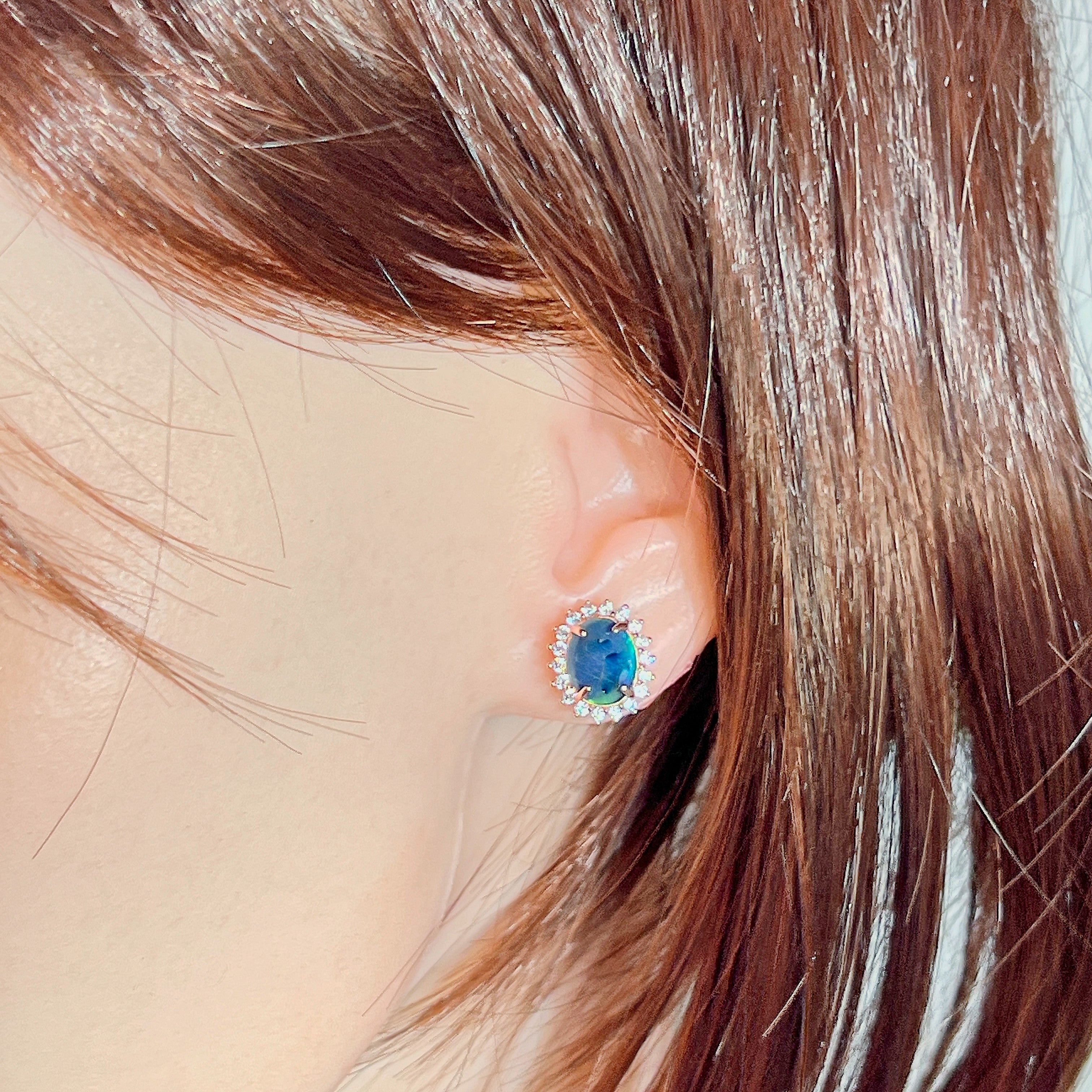 10x8mm opal triplet halo stud worn on the ear beneath loose hair