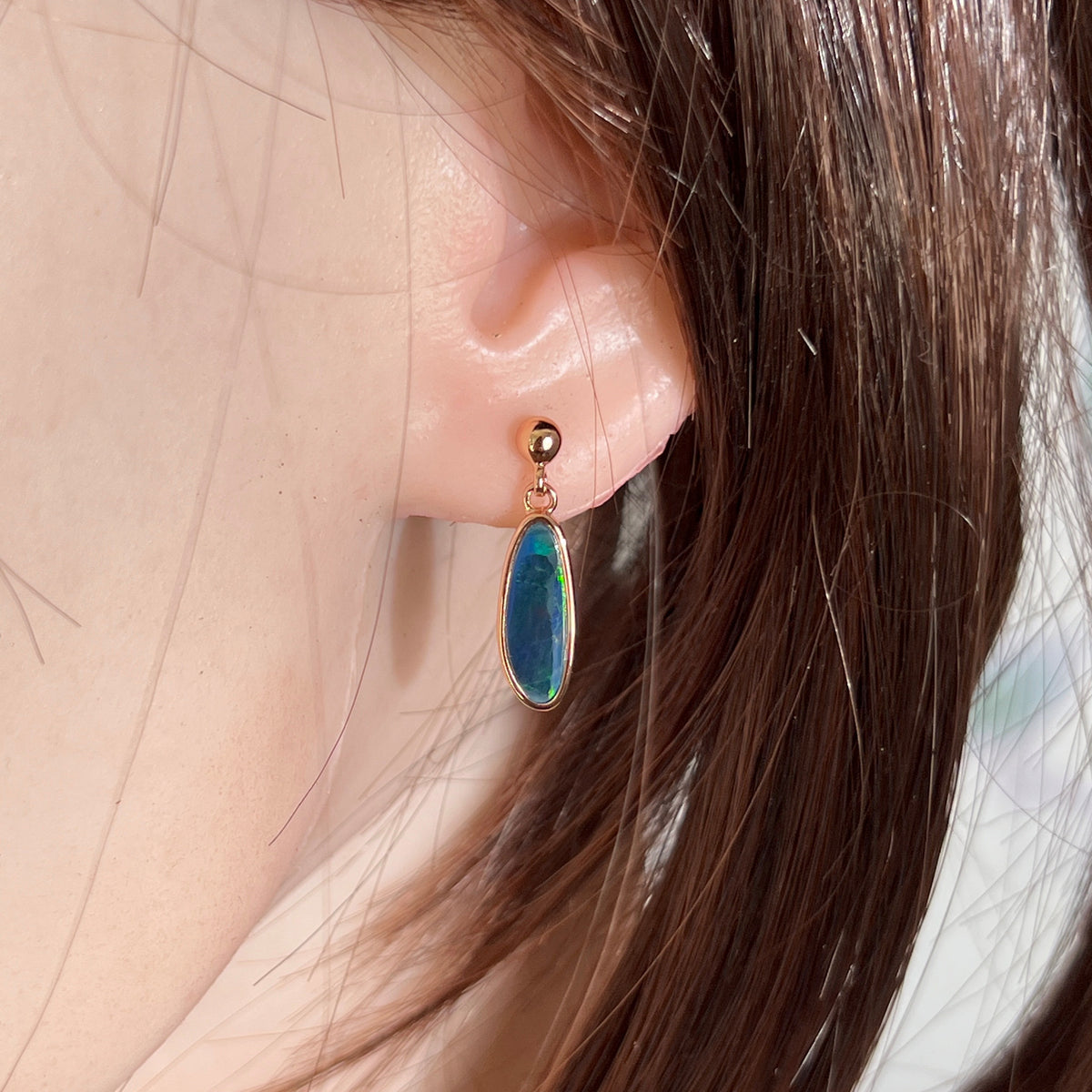freeform Australian opal doublet earrings in rose gold-plated silver, worn on the ear