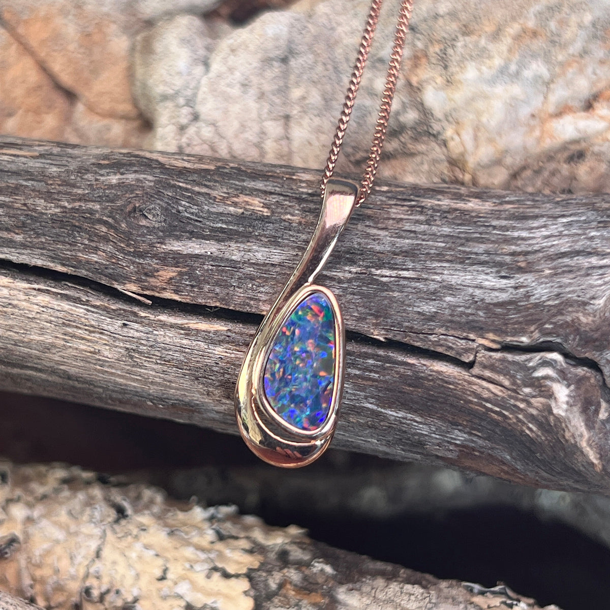 green, orange and violet play-of-colour in a 12 x 6.5mm freeform Australian opal doublet pendant
