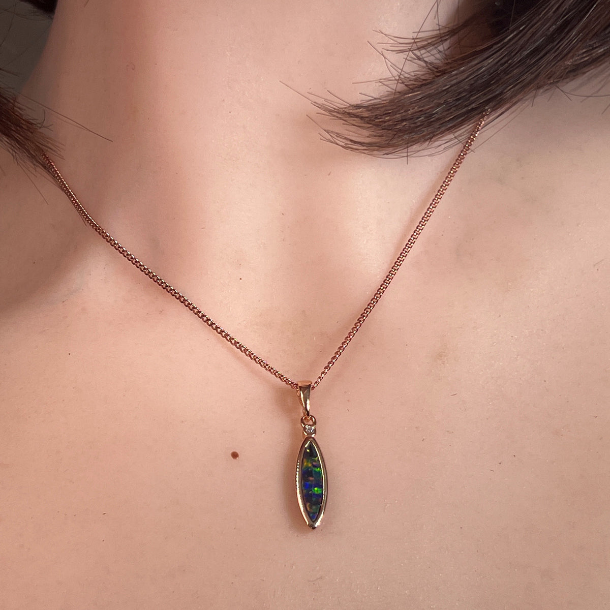 Worn Australian opal doublet pendant in rose gold-plated silver, red, blue, green and violet, 15 x 5mm