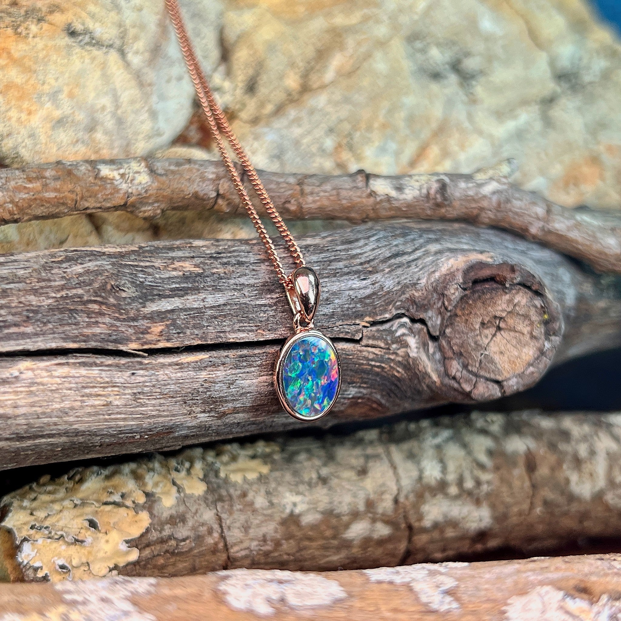 blue, yellow, green and red play-of-colour in a 10 x 8mm oval Australian opal doublet pendant