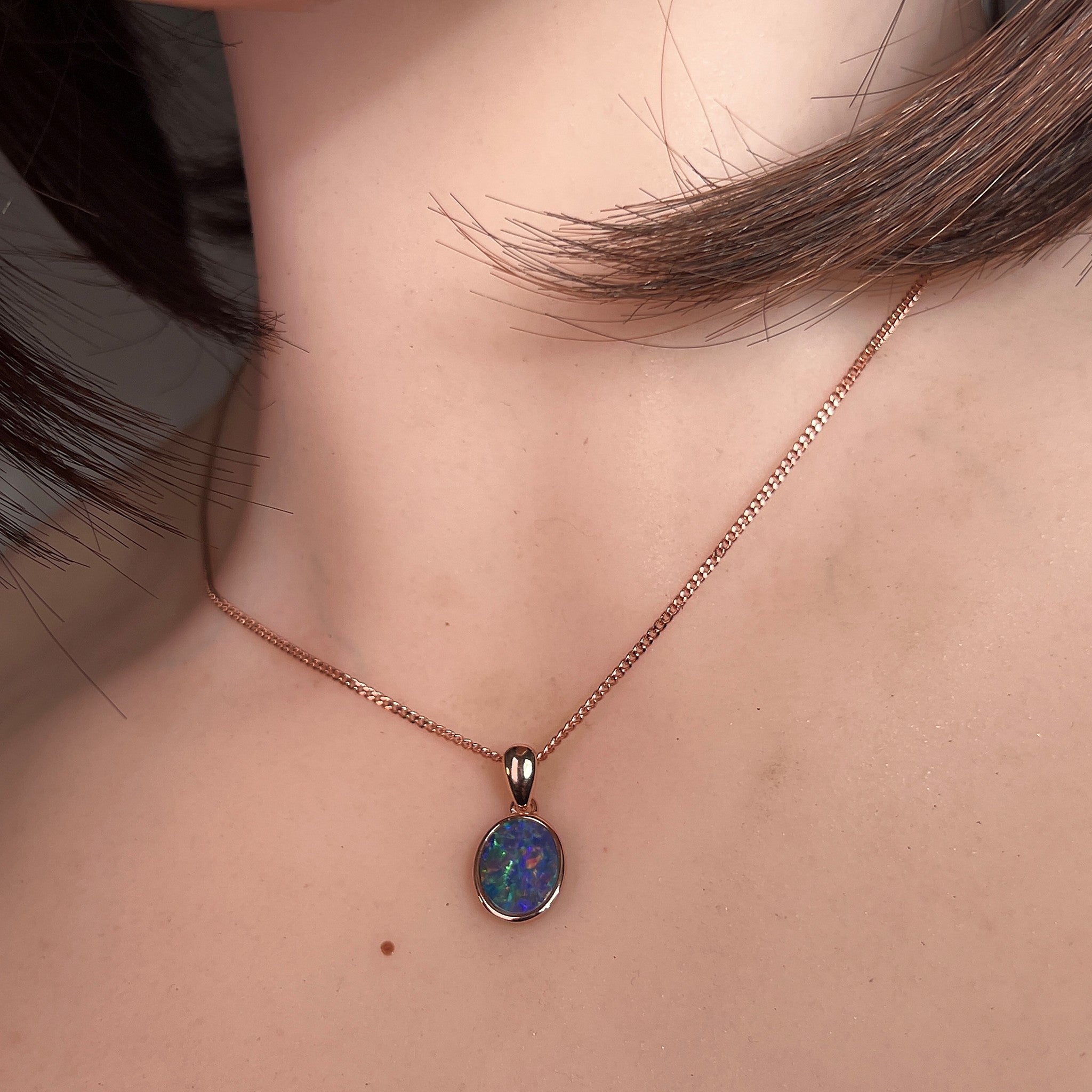 Worn Australian opal doublet pendant in rose gold-plated silver, blue, yellow, green and red, 10 x 8mm