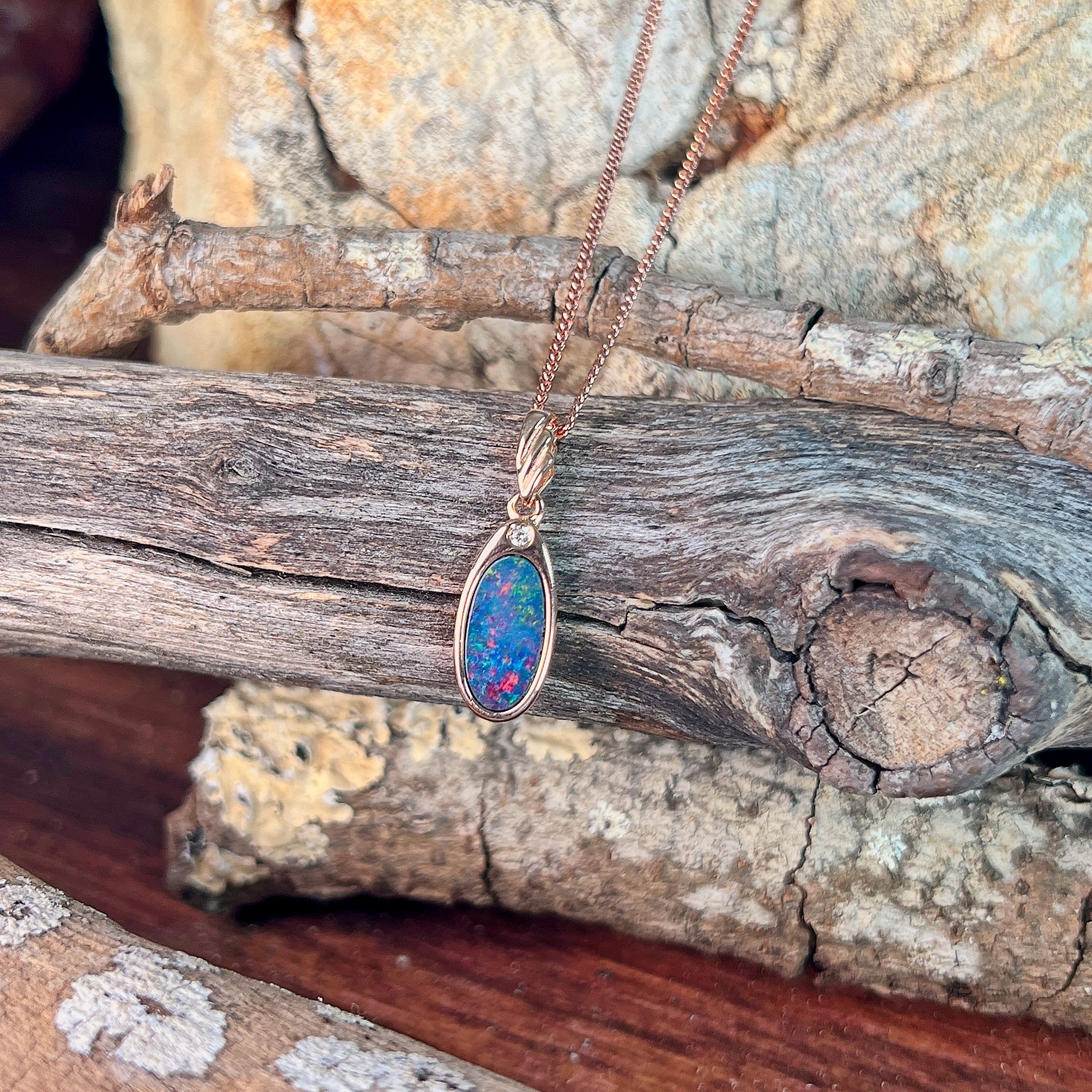 red, blue, orange and green play-of-colour in a 12 x 6.5mm oval Australian opal doublet pendant