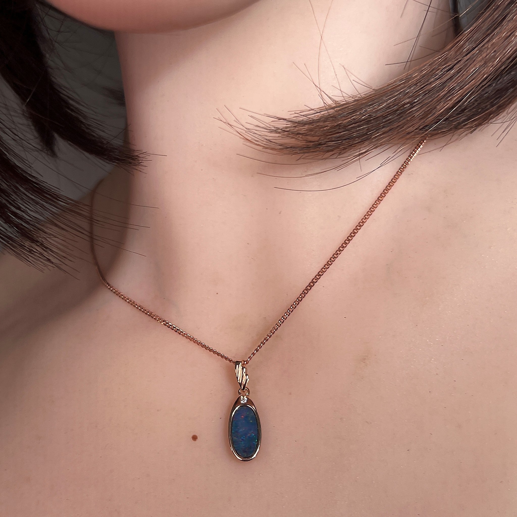Worn Australian opal doublet pendant in rose gold-plated silver, red, blue, orange and green, 12 x 6.5mm