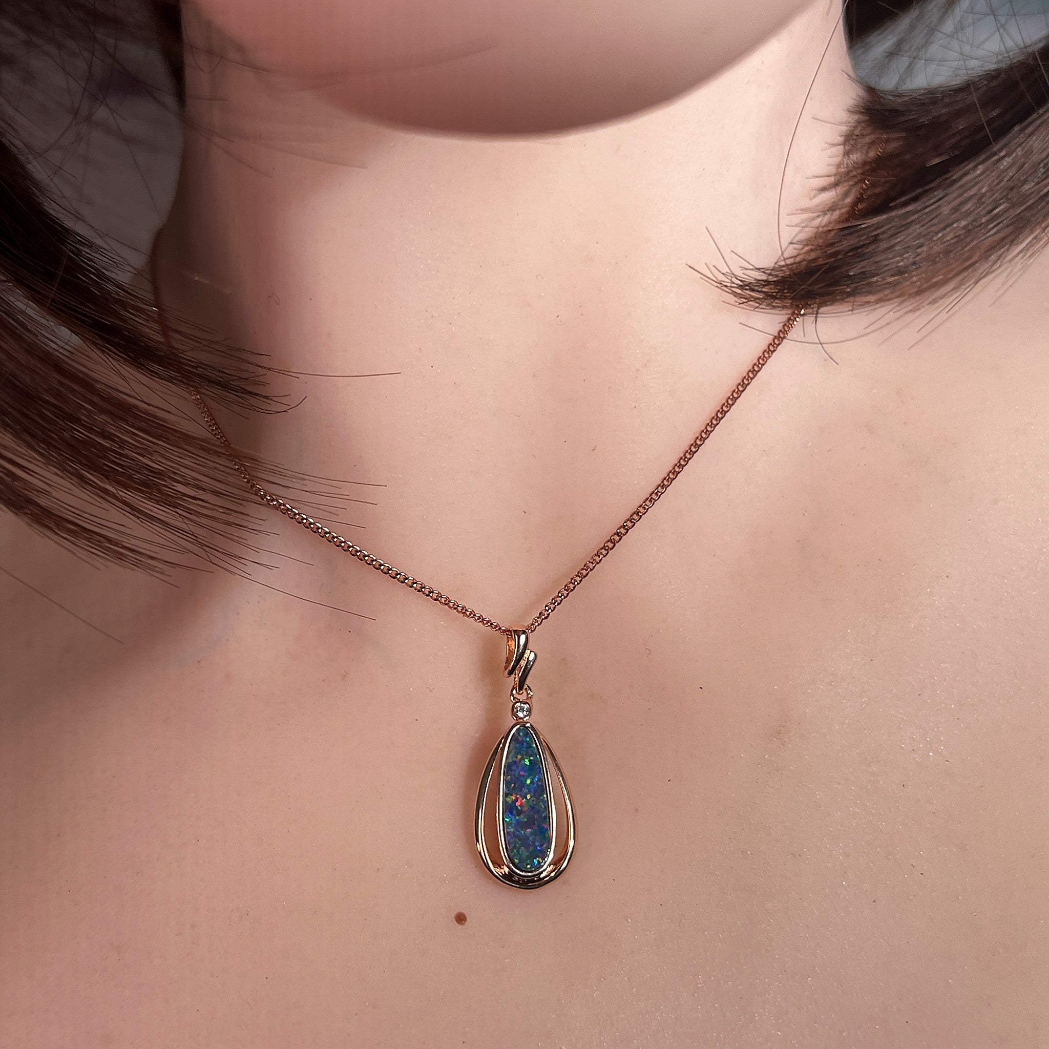 pear-shaped Australian opal doublet pendant in rose gold-plated silver, worn at the neck