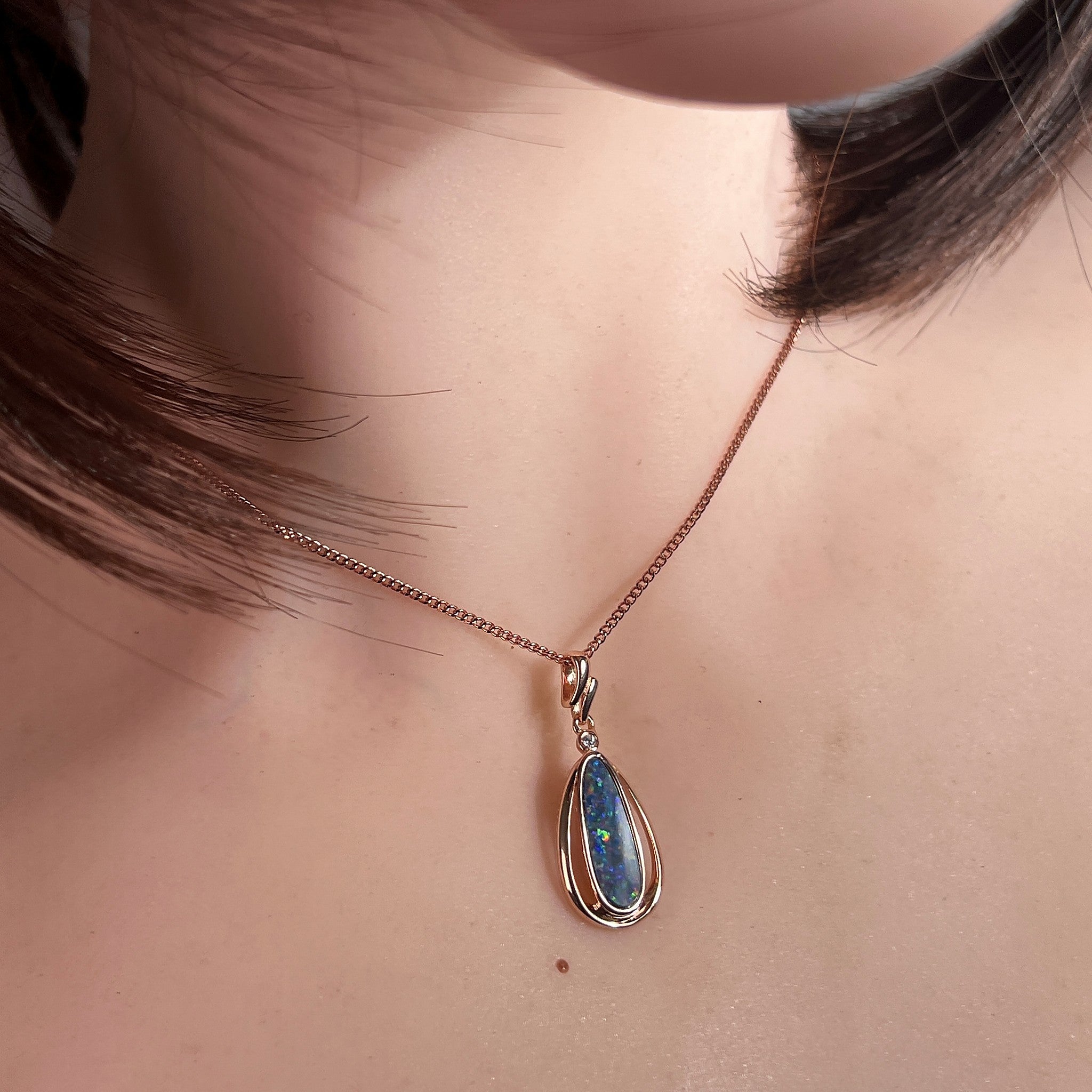 Australian opal doublet pendant worn at the neck, blue, yellow, green and red play-of-colour