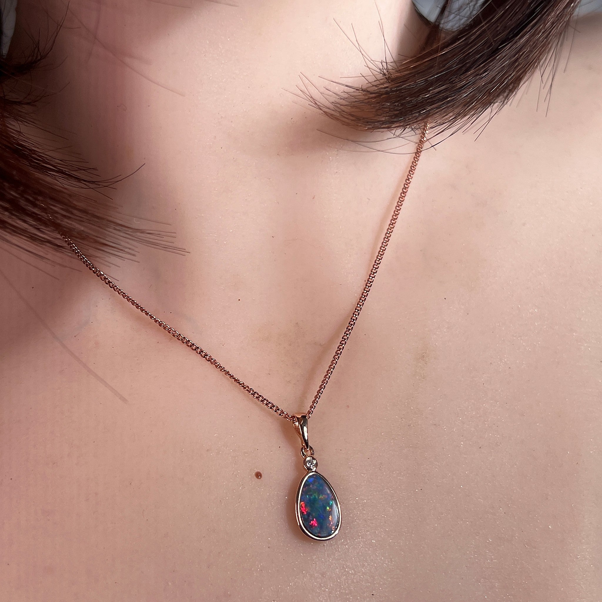 11 x 7mm pear-shaped Australian opal doublet pendant worn at the neck, rose gold-plated silver