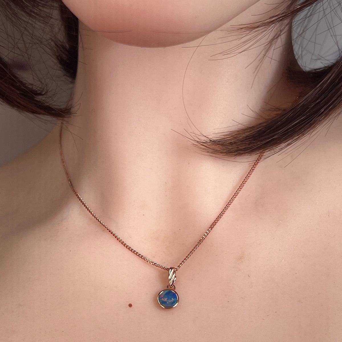 Australian opal doublet pendant worn at the neck, rose gold-plated silver, 6mm round stone
