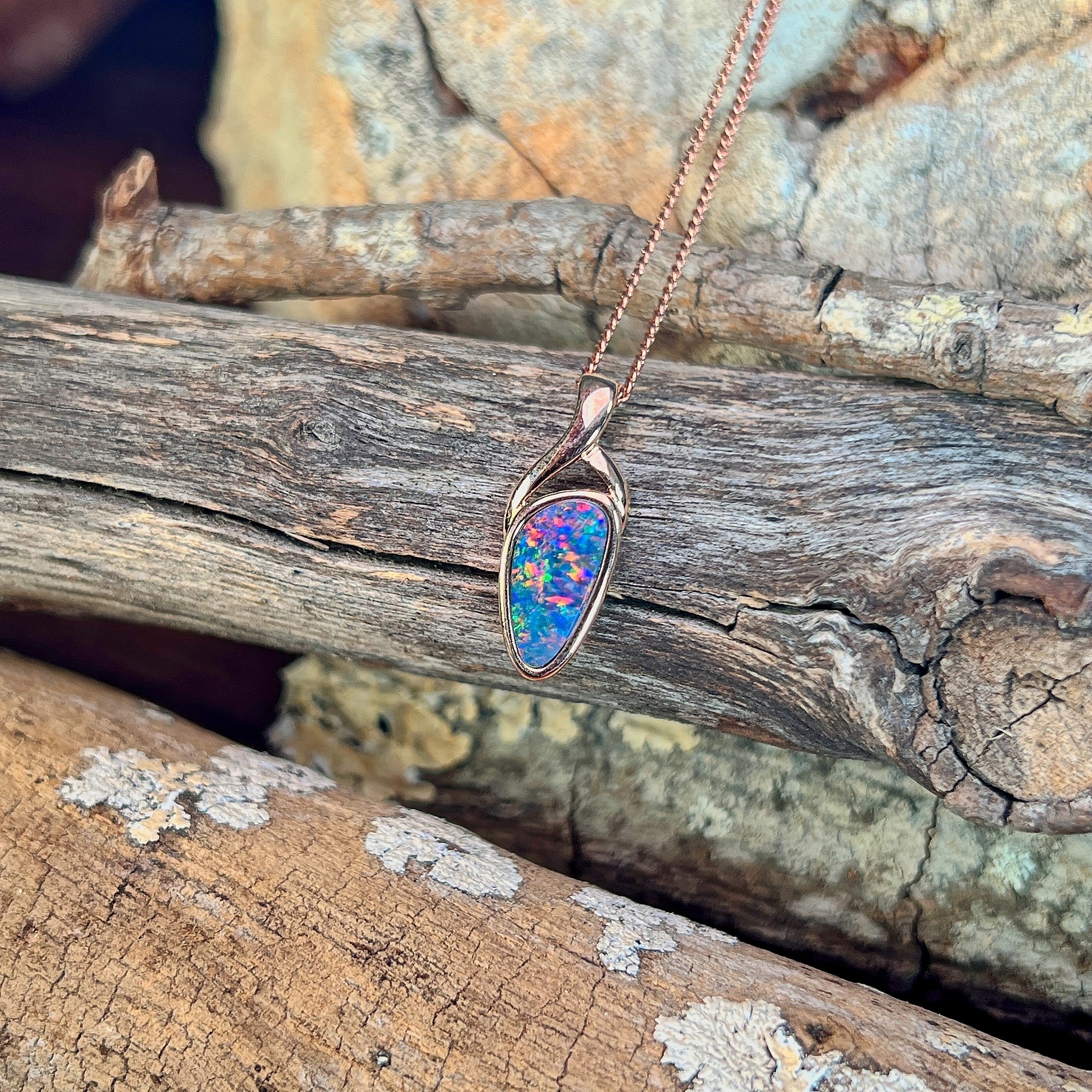 blue, yellow, green and red play-of-colour in a 11 x 5.5mm triangular Australian opal doublet pendant