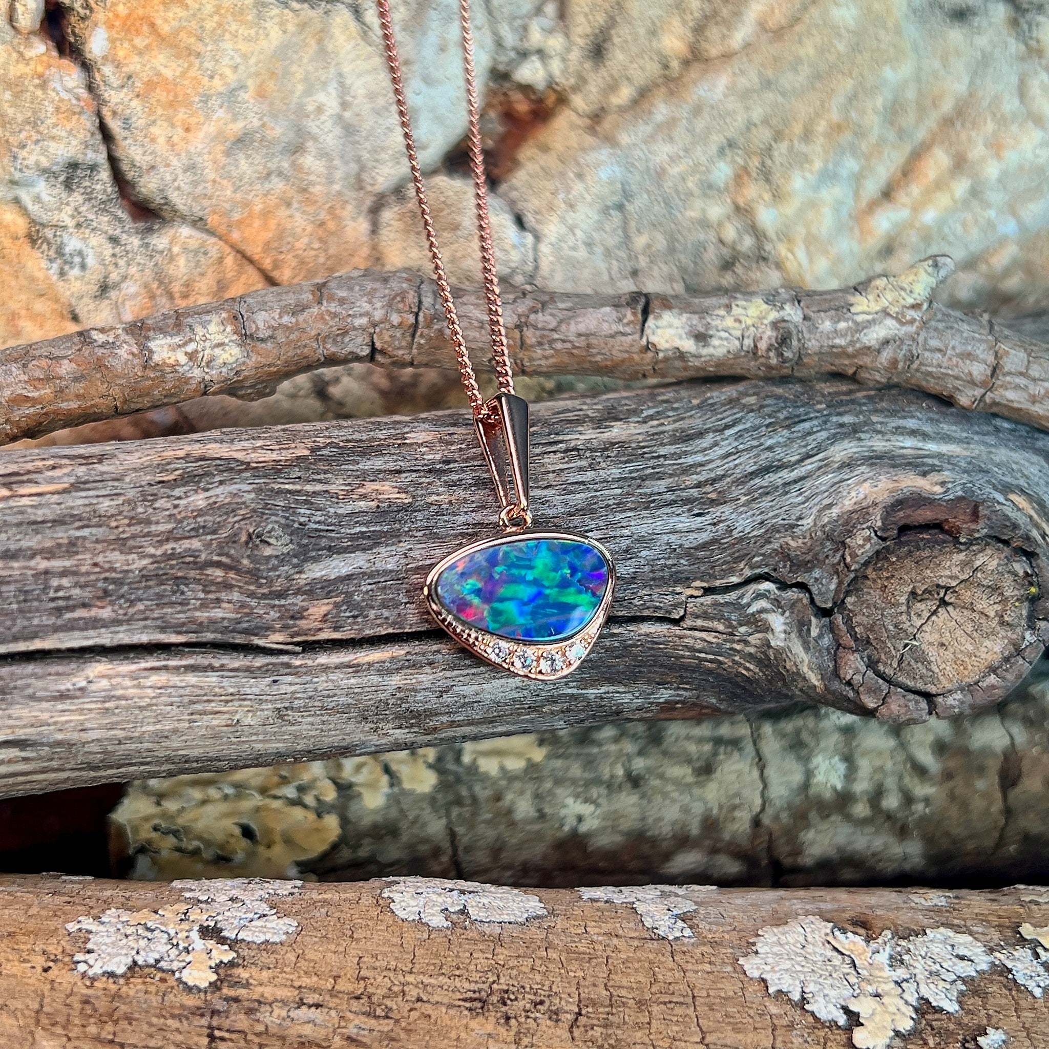 blue, yellow, green and red play-of-colour in a 13 x 7mm triangular Australian opal doublet pendant