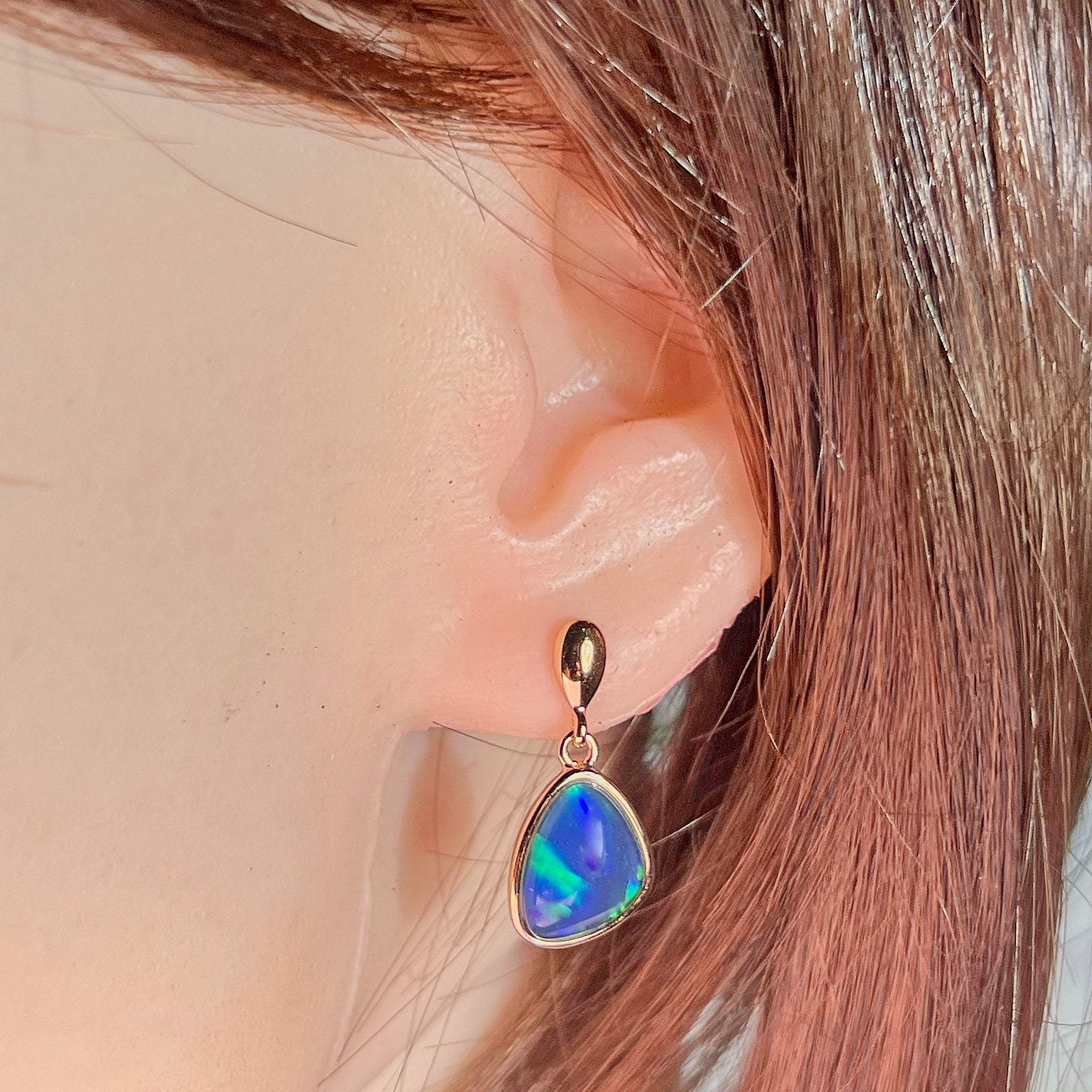 triangular Australian opal triplet earrings in rose gold-plated silver, worn on the ear