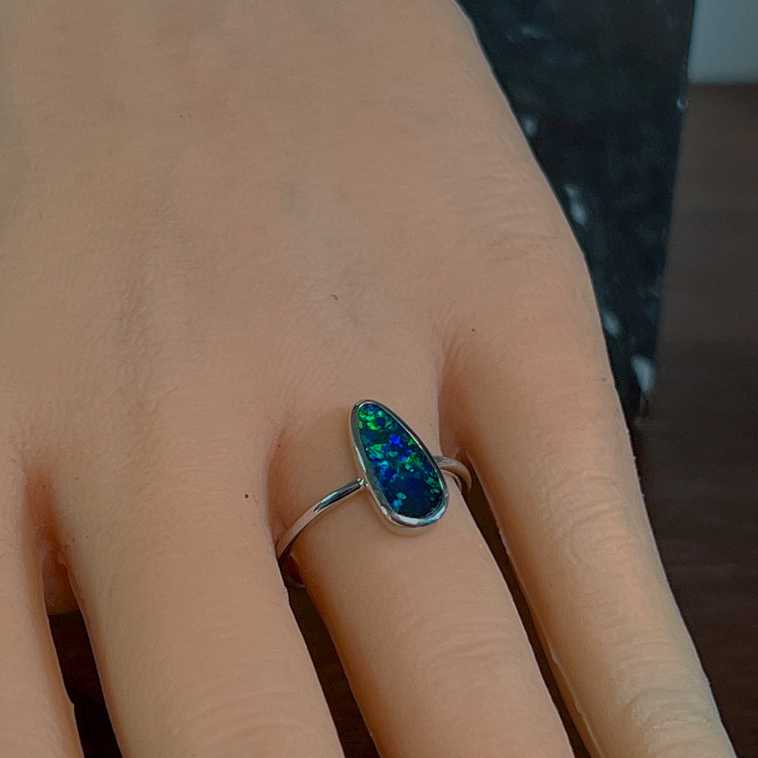 Elongated opal doublet ring in sterling silver worn on the hand, side view