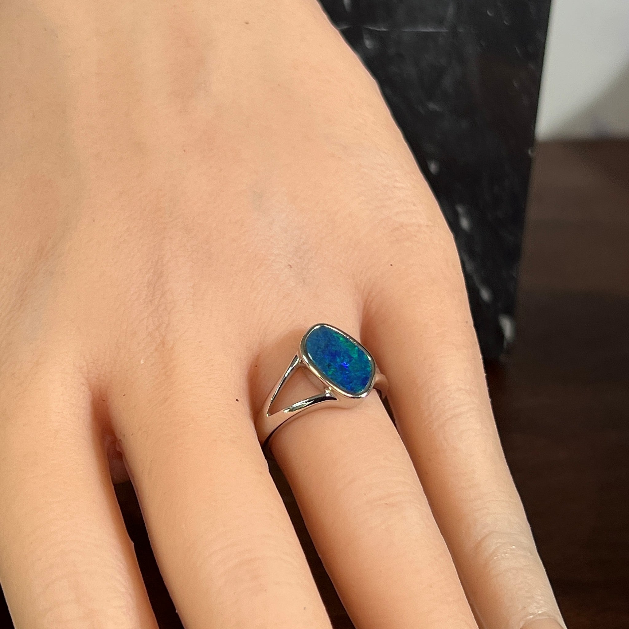 Freeform opal doublet ring in silver worn on the hand, showing its scale on the finger