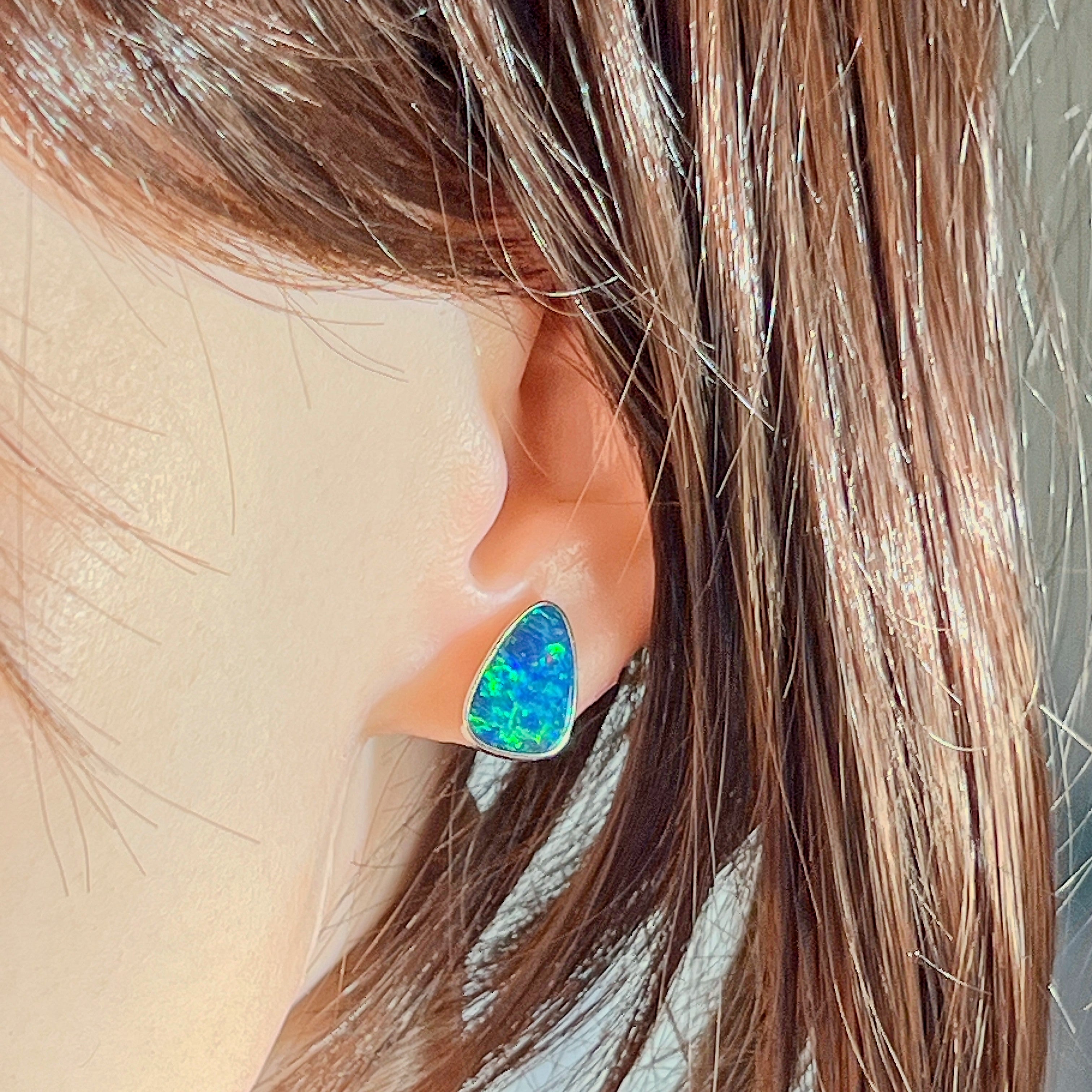 Opal doublet stud earring in sterling silver worn on the ear, side profile view