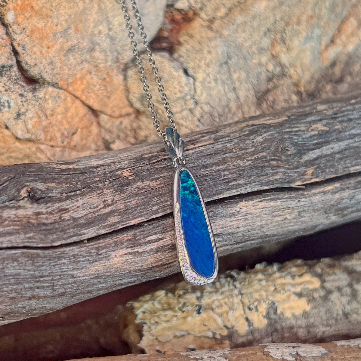 blue and green play-of-colour in a 20 x 6mm oval Australian opal doublet pendant