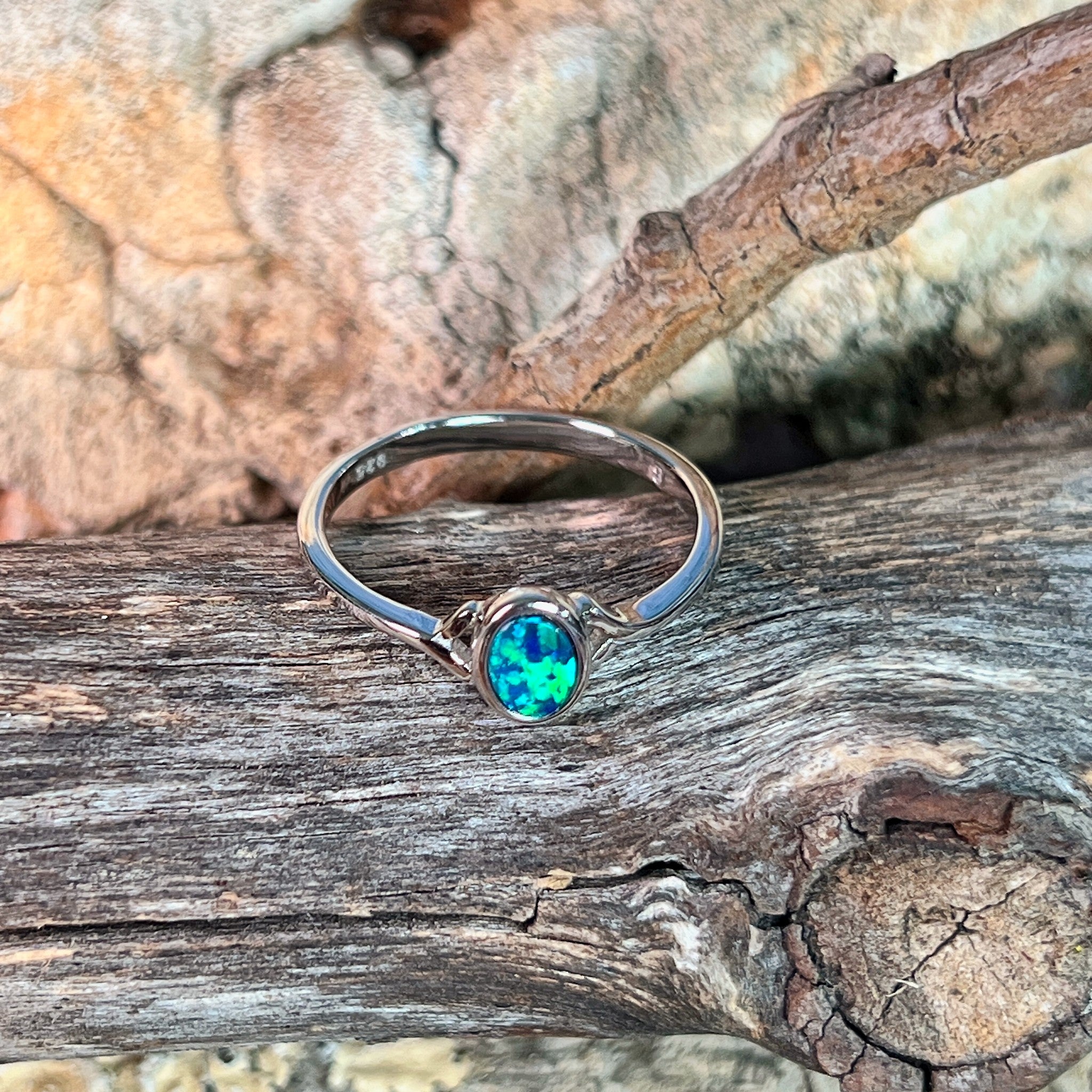 Close view of the green and black play of colour in the oval opal doublet