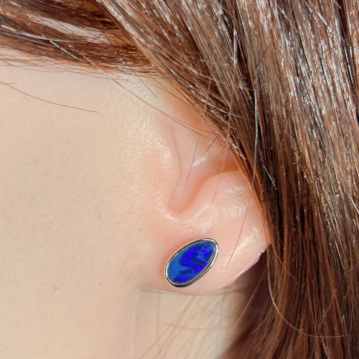 11 x 6mm pear-shaped Australian opal doublet earrings worn on the ear, sterling silver