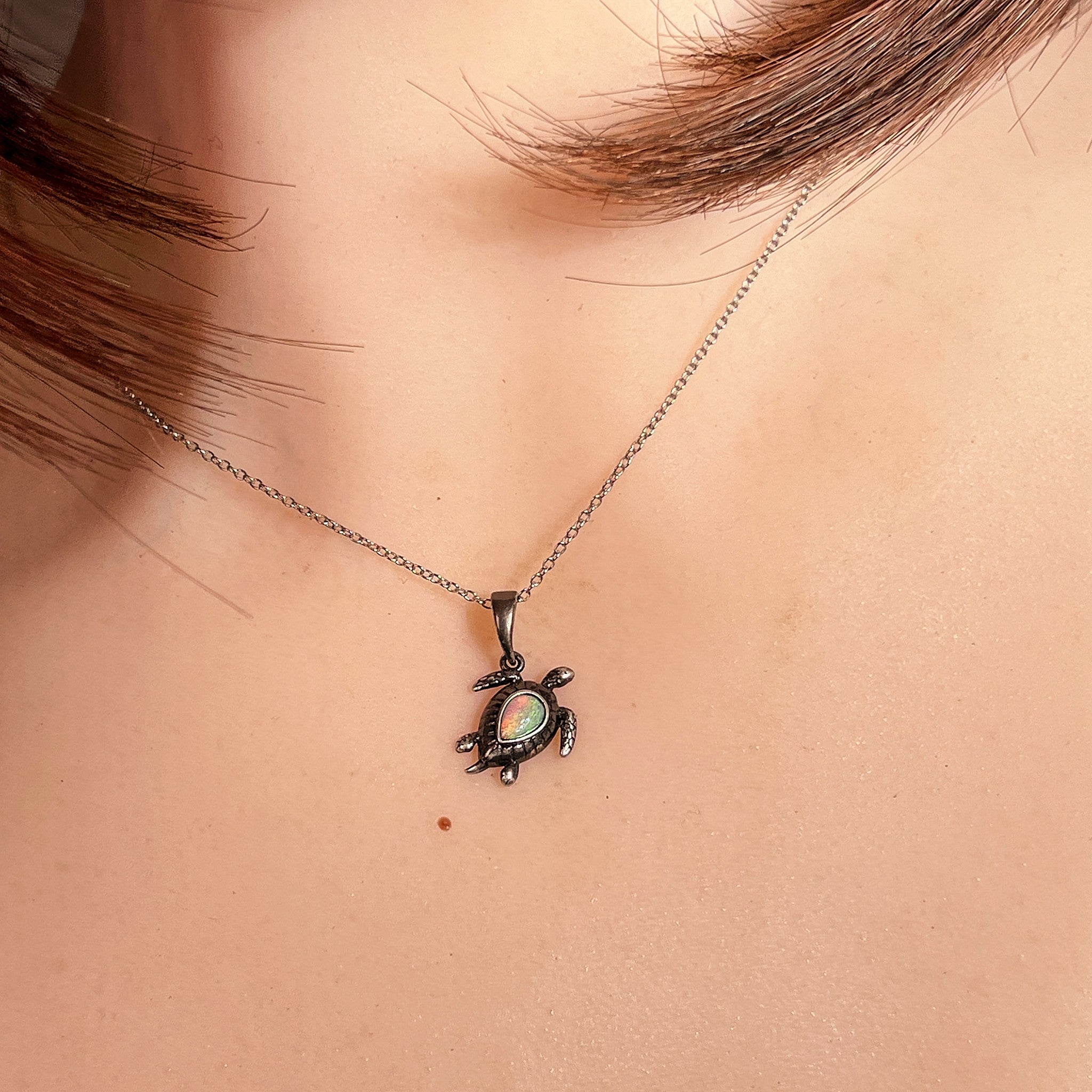 Worn Australian crystal opal pendant in sterling silver, red, green, blue and pink, 7 x 5mm