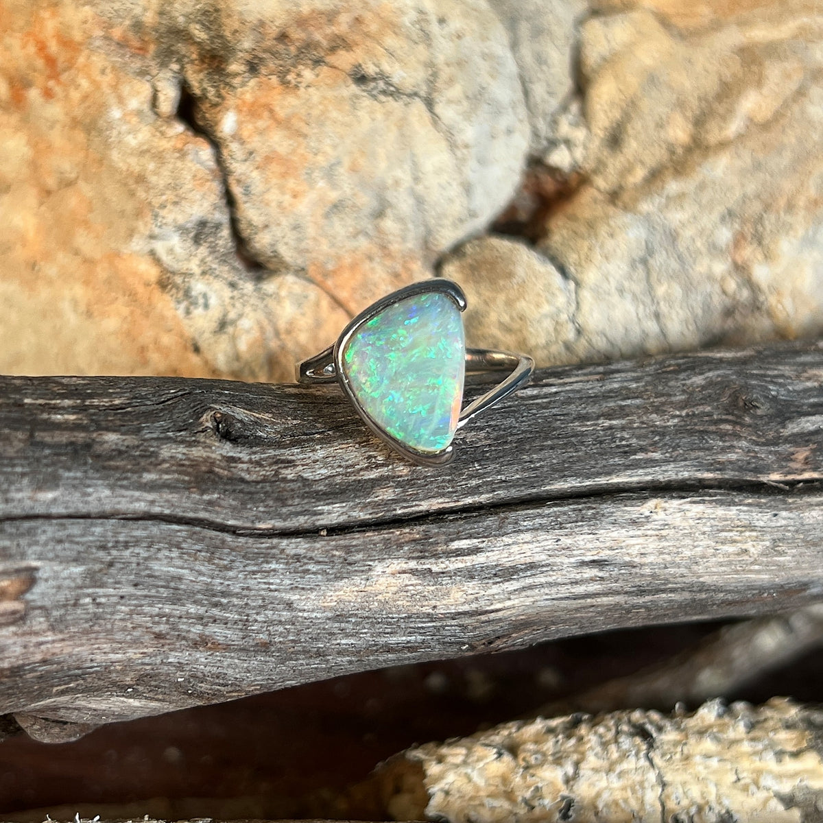 Triangular crystal opal ring in sterling silver, 1.8ct solid opal, green and blue play-of-colour, on weathered timber