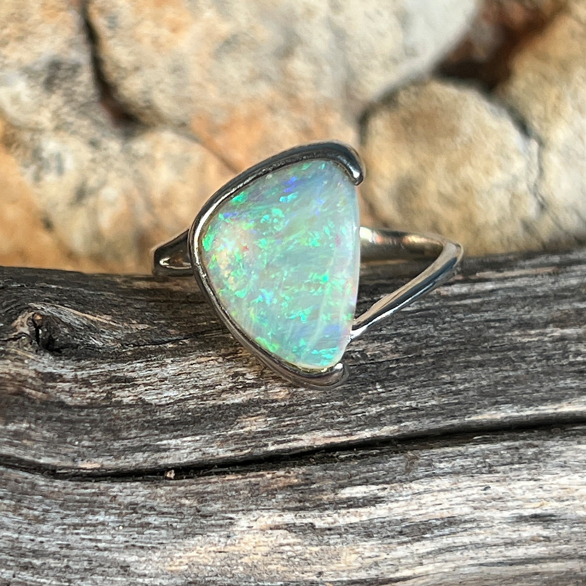 Sterling silver ring, solid Australian crystal opal 1.8ct triangular, half bezel set, green and blue, on timber