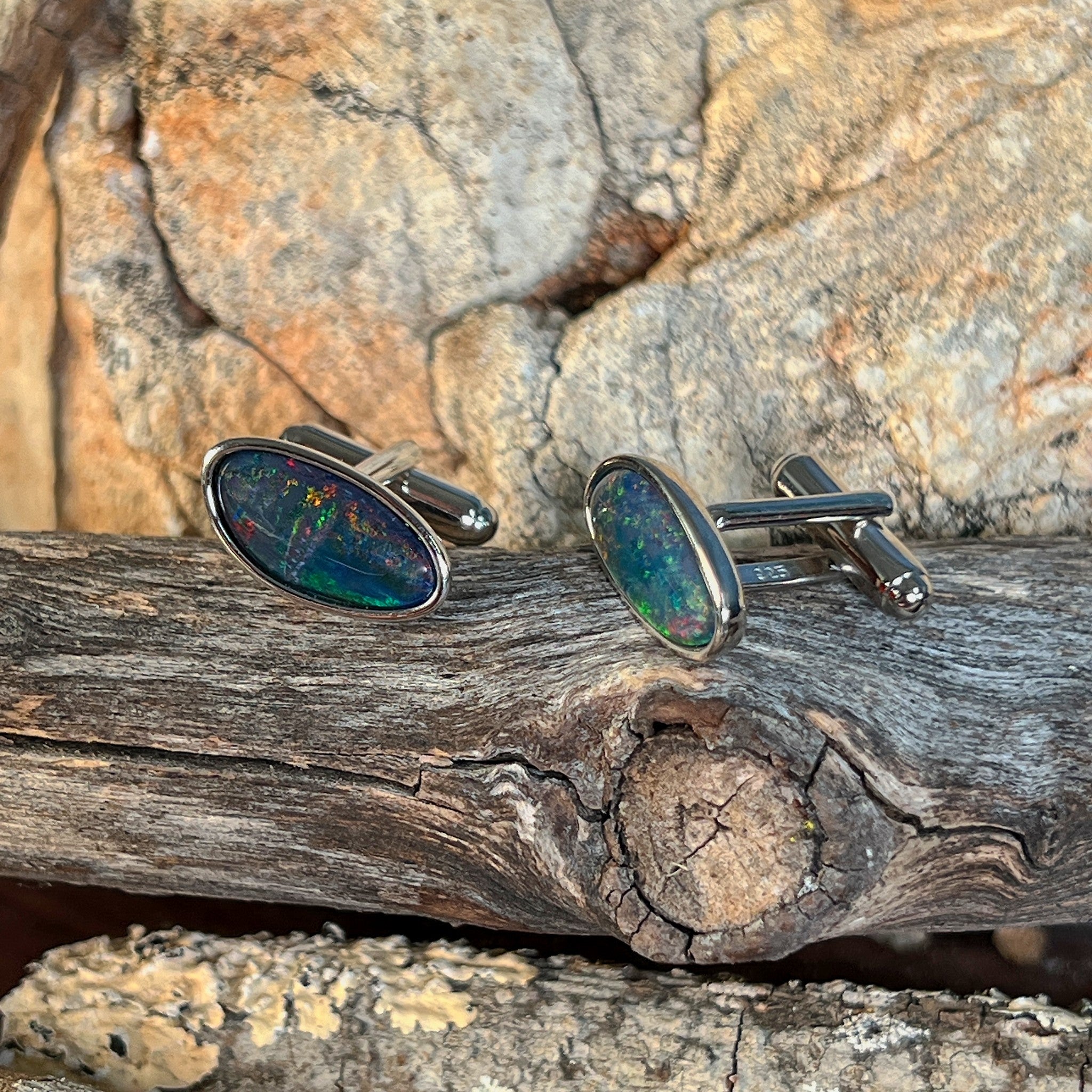 Close view of the red, orange, yellow and green play of colour in the freeform opal triplet