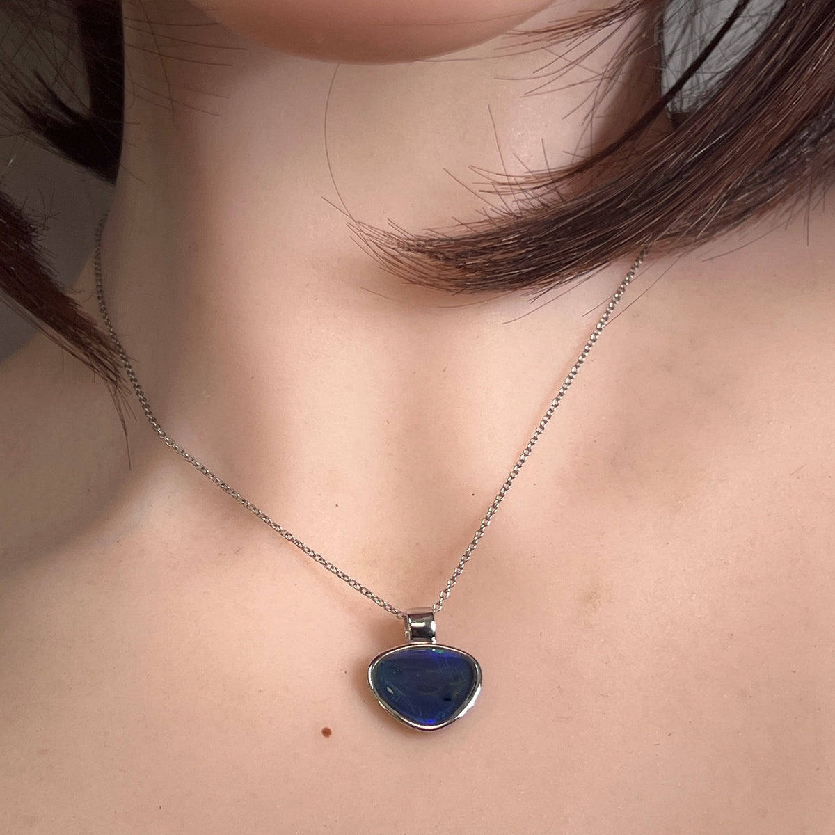 Australian opal triplet pendant worn at the neck, sterling silver, 12 x 15mm freeform stone