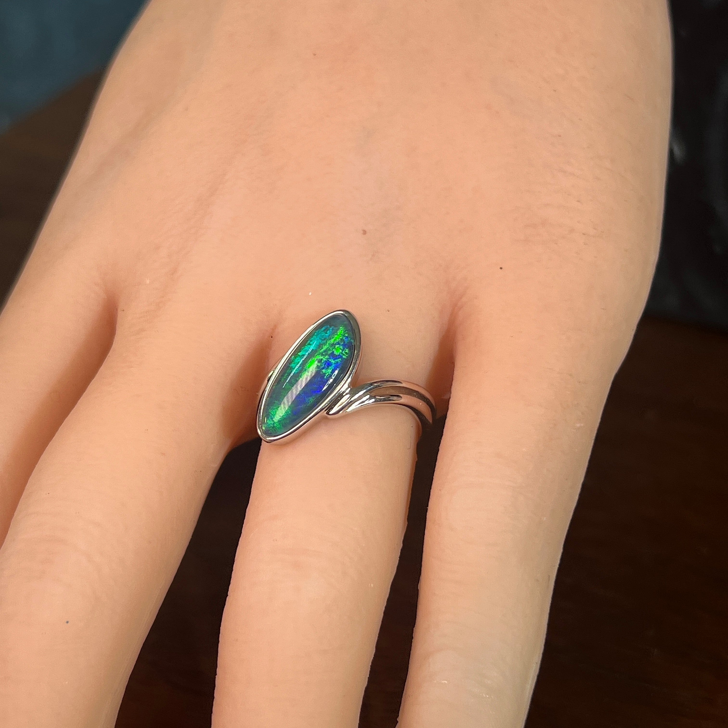 Australian opal triplet ring worn on the hand, blue and green play-of-colour