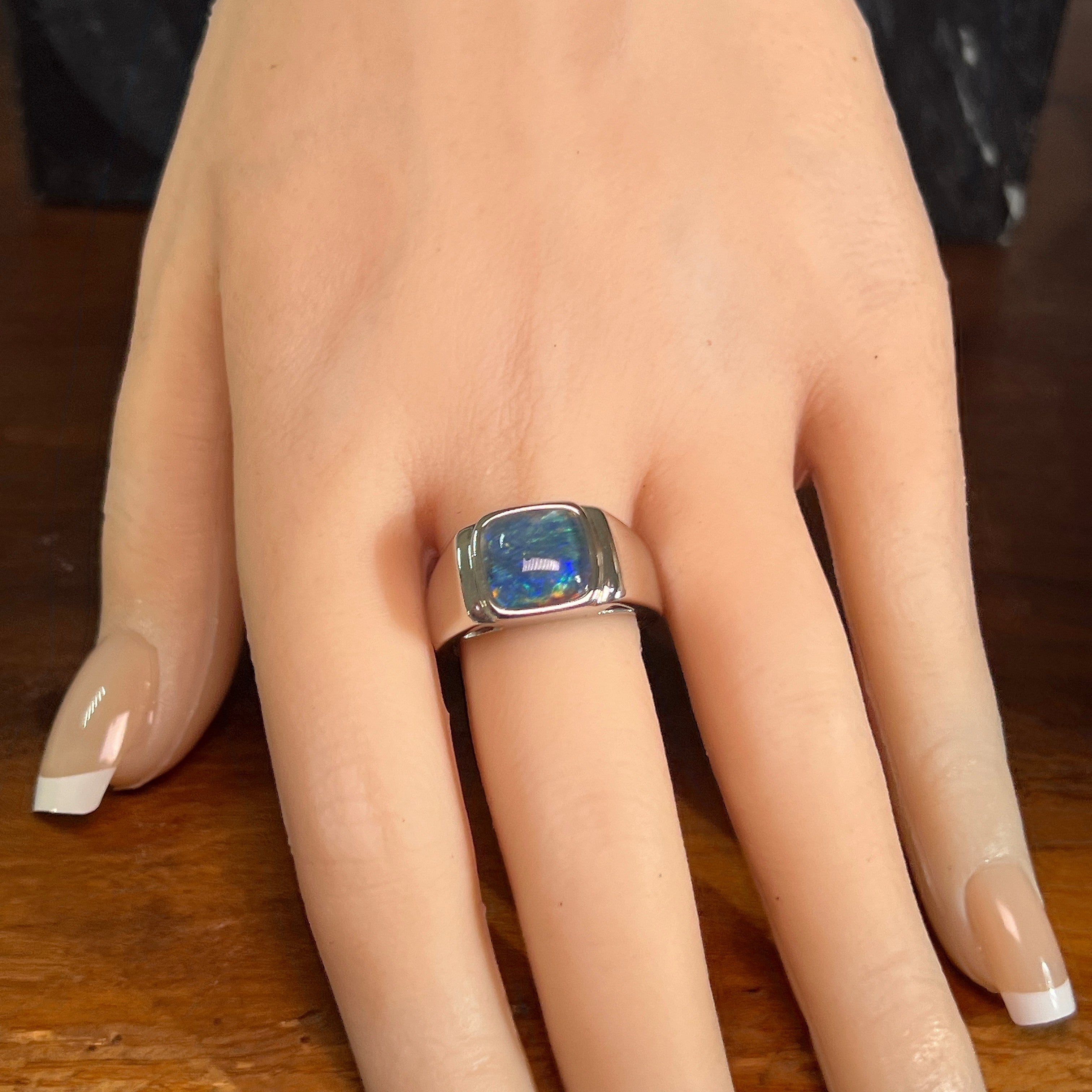 Australian opal triplet ring worn on the hand, yellow, orange, blue and green play-of-colour