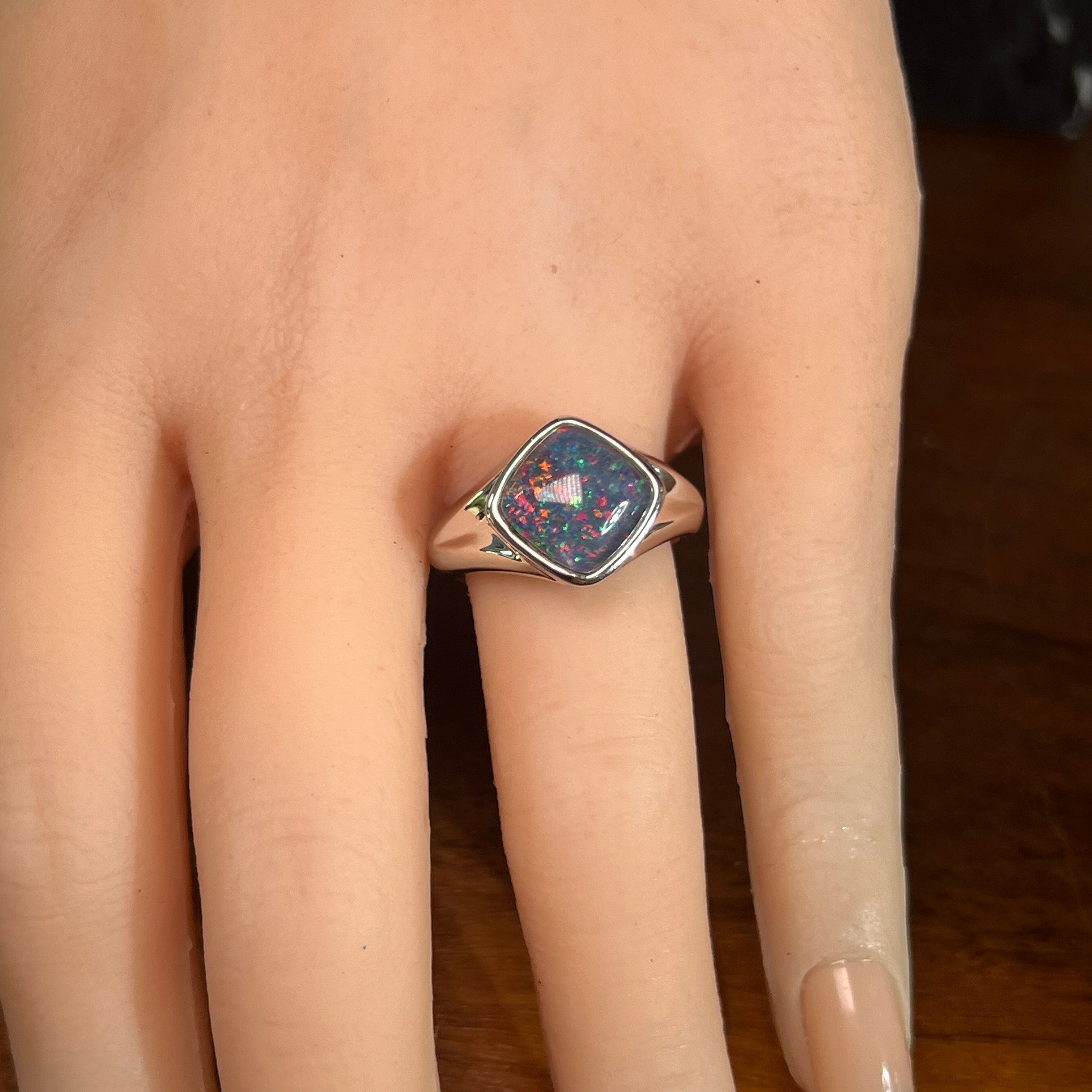 cushion-shaped Australian opal triplet ring worn, sterling silver, red, blue and green