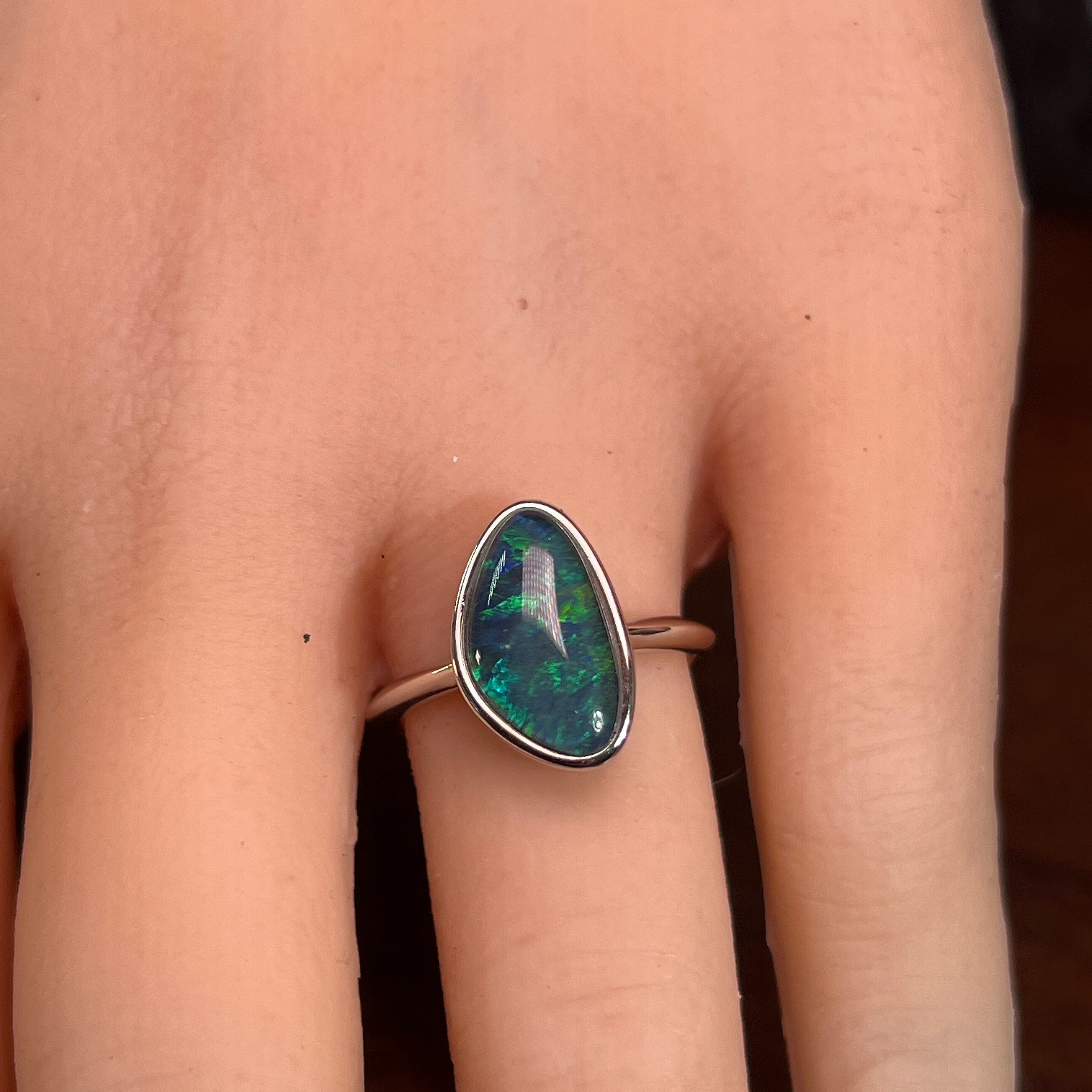 Australian opal triplet ring worn on the hand, yellow, blue and green play-of-colour