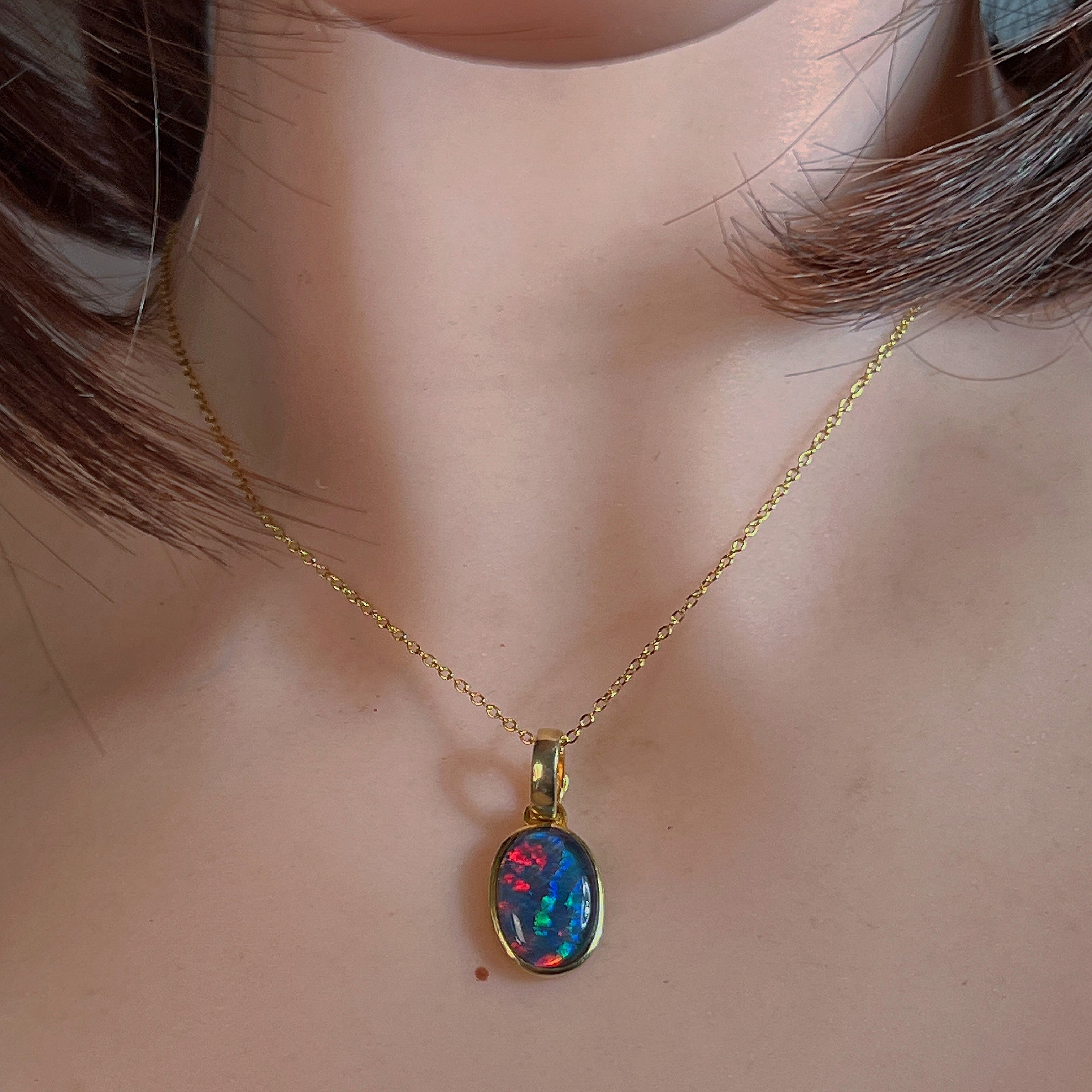 Gold-plated silver opal triplet pendant worn at the neckline, close view