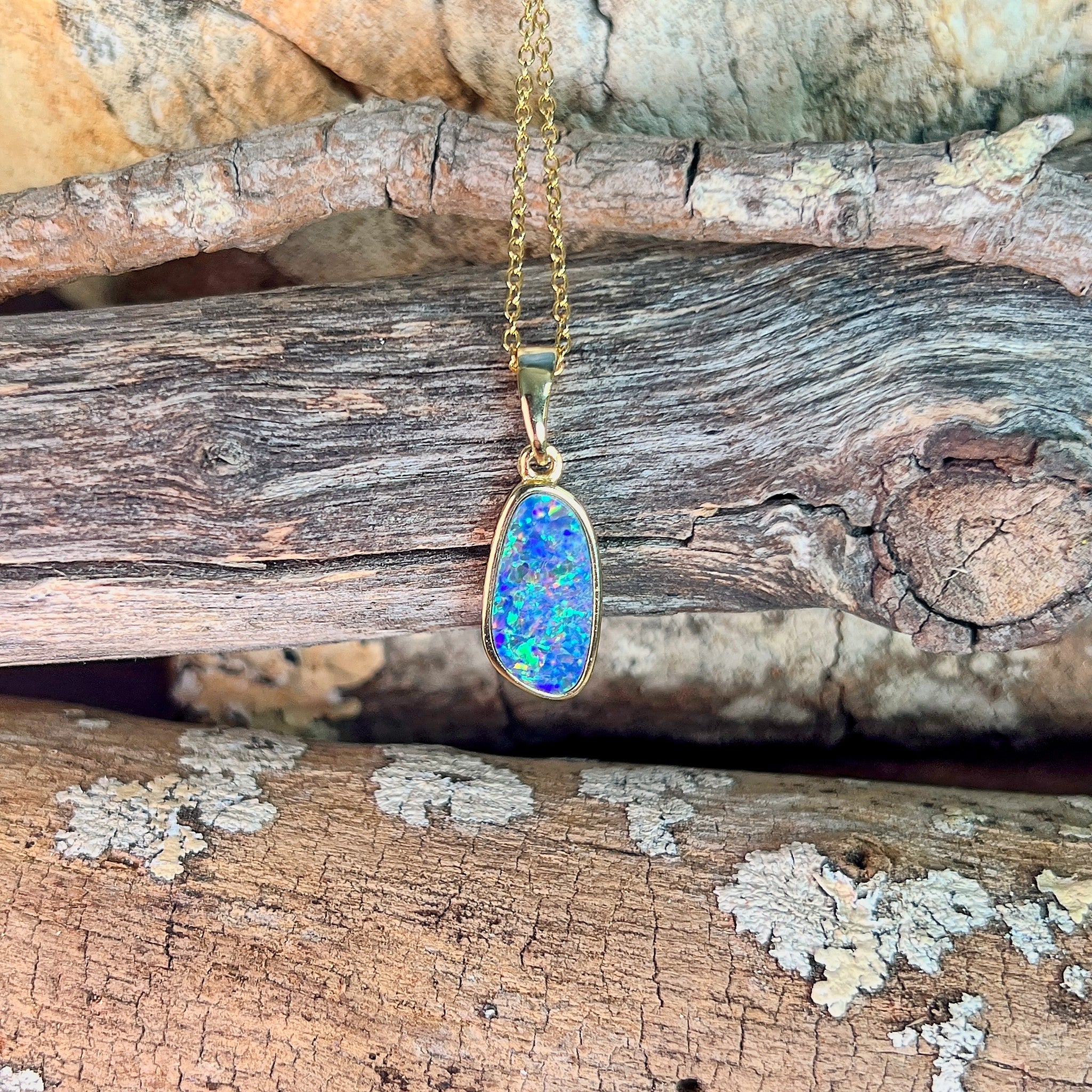 blue, red and yellow play-of-colour in a 15 x 7mm freeform Australian opal doublet pendant