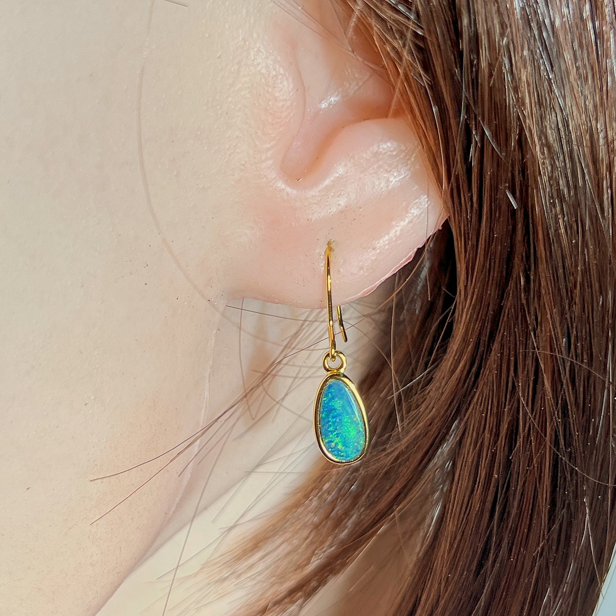 oval Australian opal doublet earrings in yellow gold-plated silver, worn on the ear