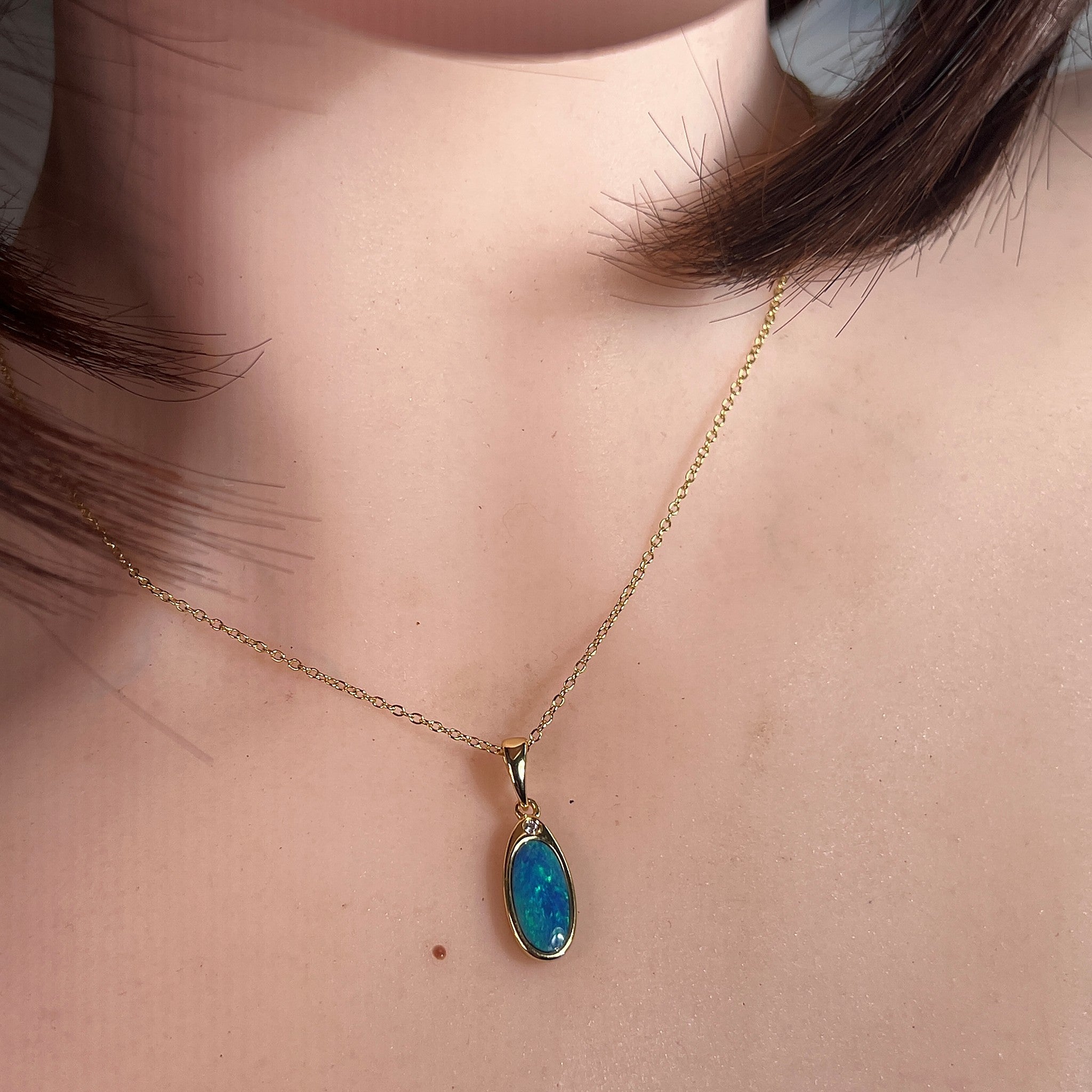 Australian opal doublet pendant worn at the neck, blue and green play-of-colour
