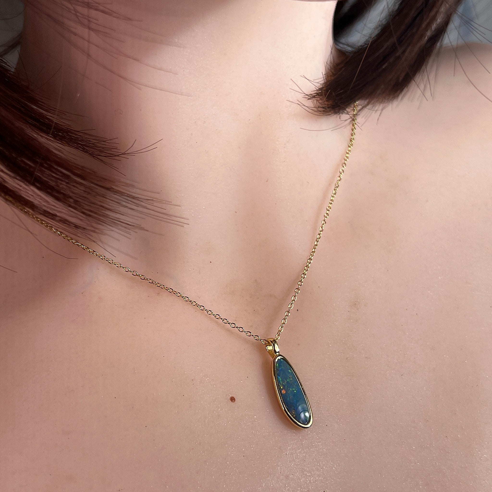 Australian opal doublet pendant worn at the neck, blue, red and yellow play-of-colour