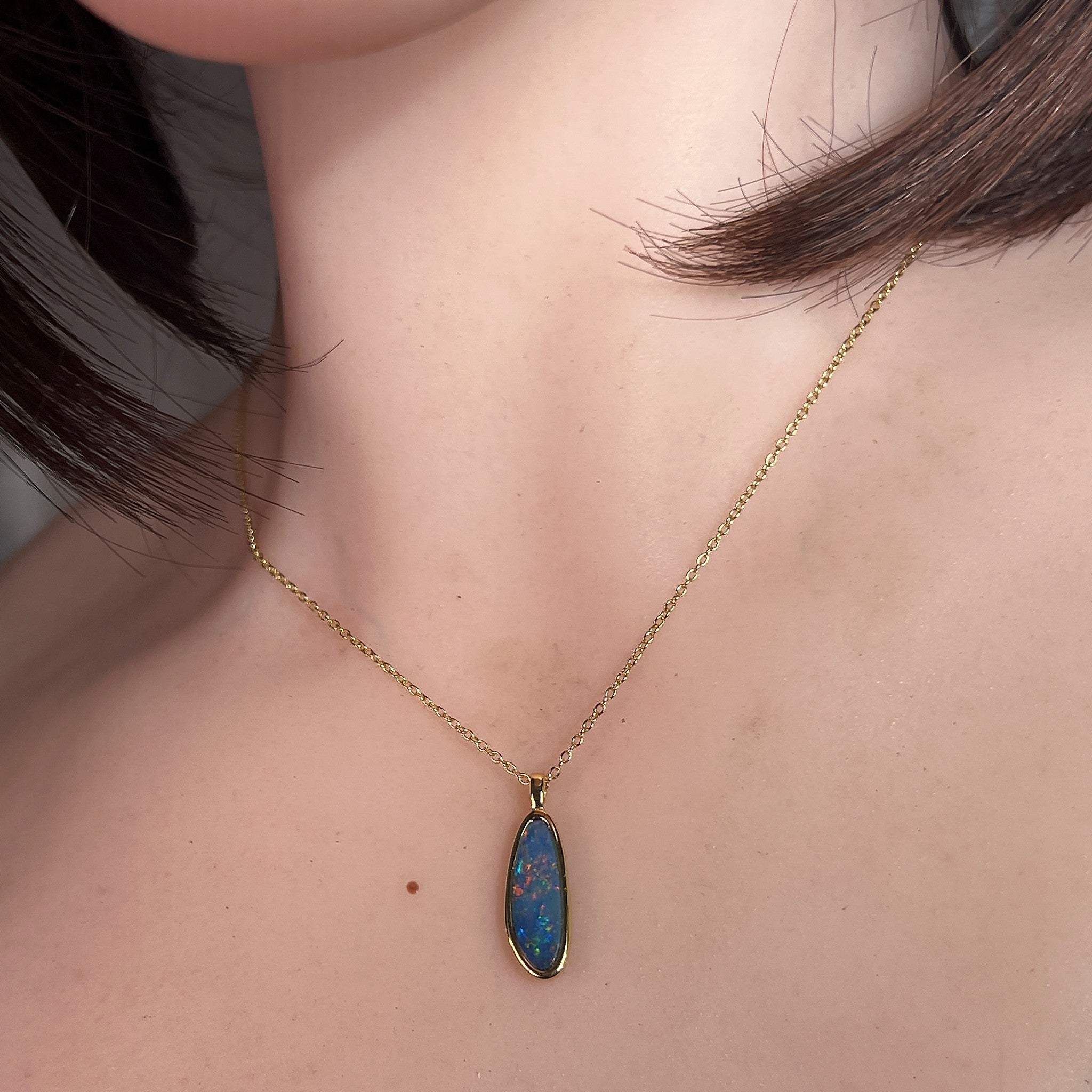 17 x 6mm pear-shaped Australian opal doublet pendant worn at the neck, yellow gold-plated silver