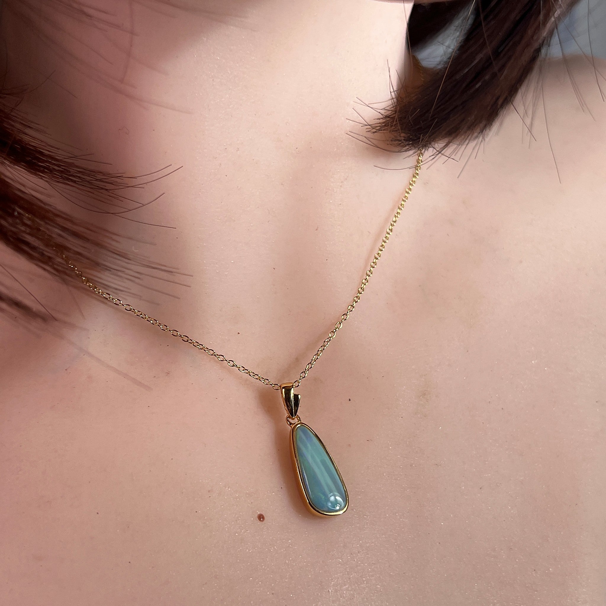 Australian opal doublet pendant worn at the neck, yellow gold-plated silver, 17 x 6mm pear-shaped stone