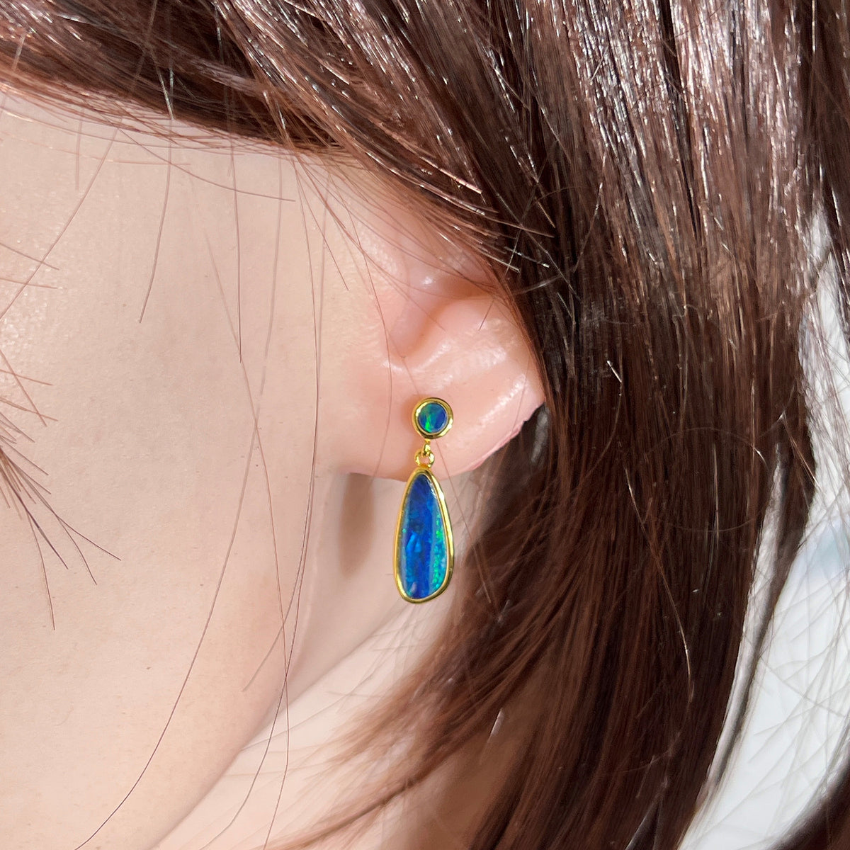Worn Australian opal doublet earrings in yellow gold-plated silver, green and blue, 16.5 x 7mm and 5mm