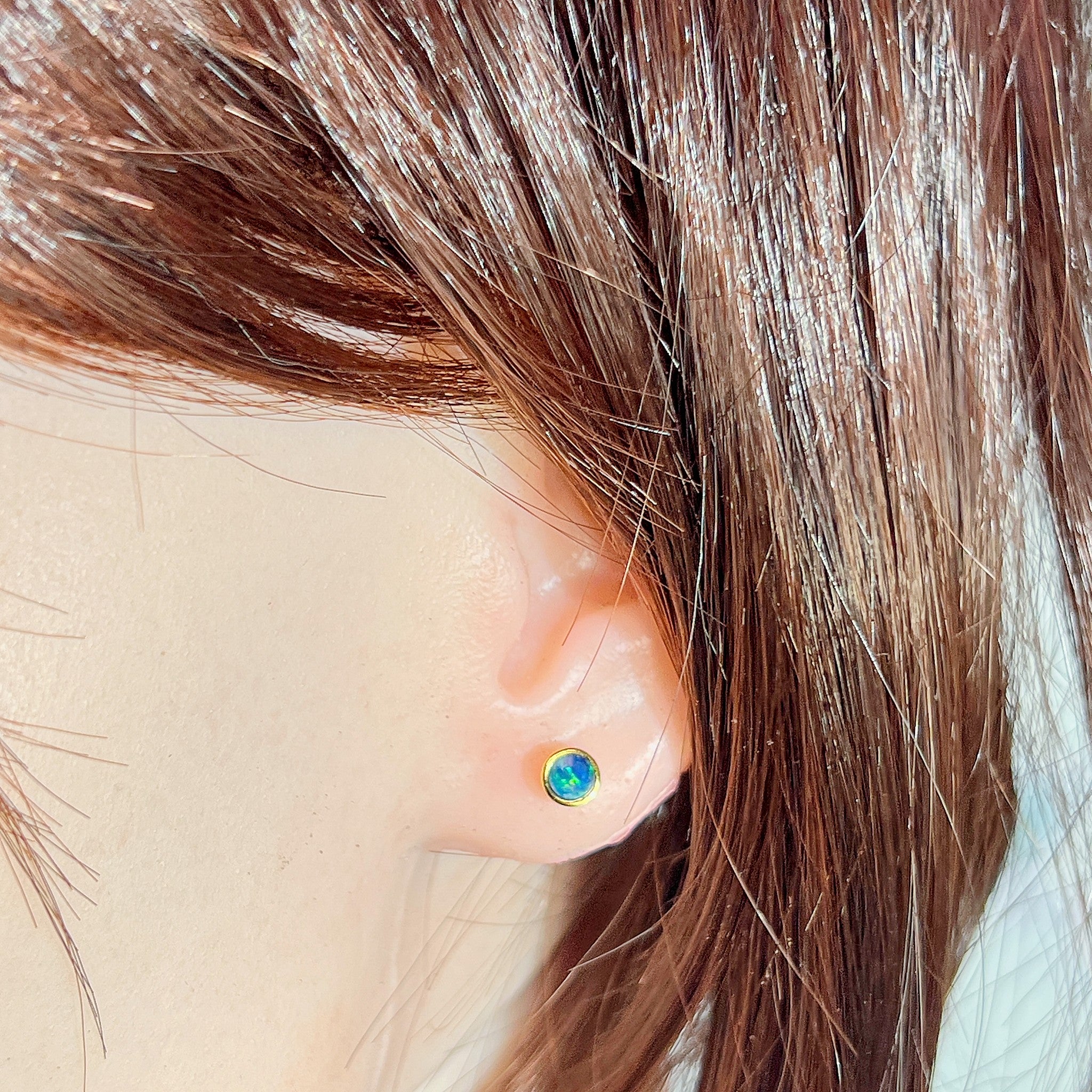 round Australian opal doublet earrings in yellow gold-plated silver, worn on the ear