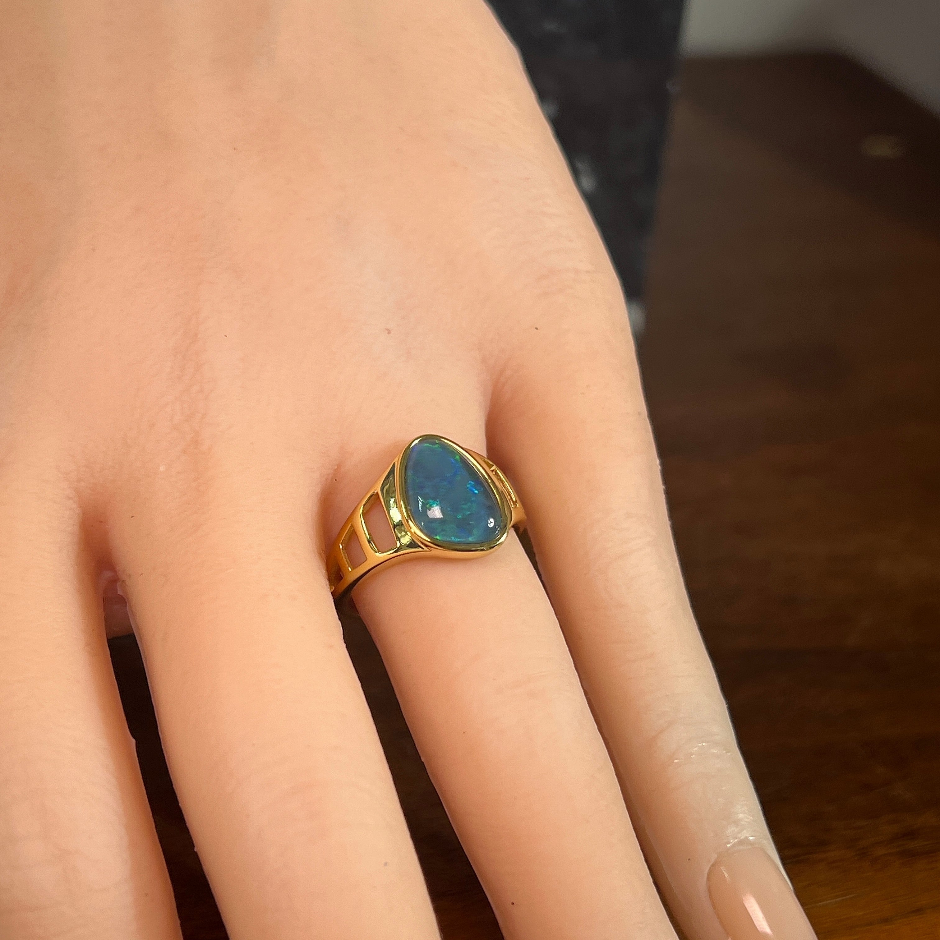 12 x 9mm freeform Australian opal triplet ring on the hand, yellow gold-plated silver