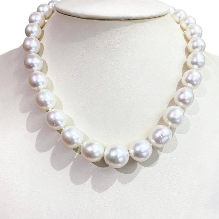 White South Sea pearl strand with 14kt white gold ball clasp, displayed on a cream bust